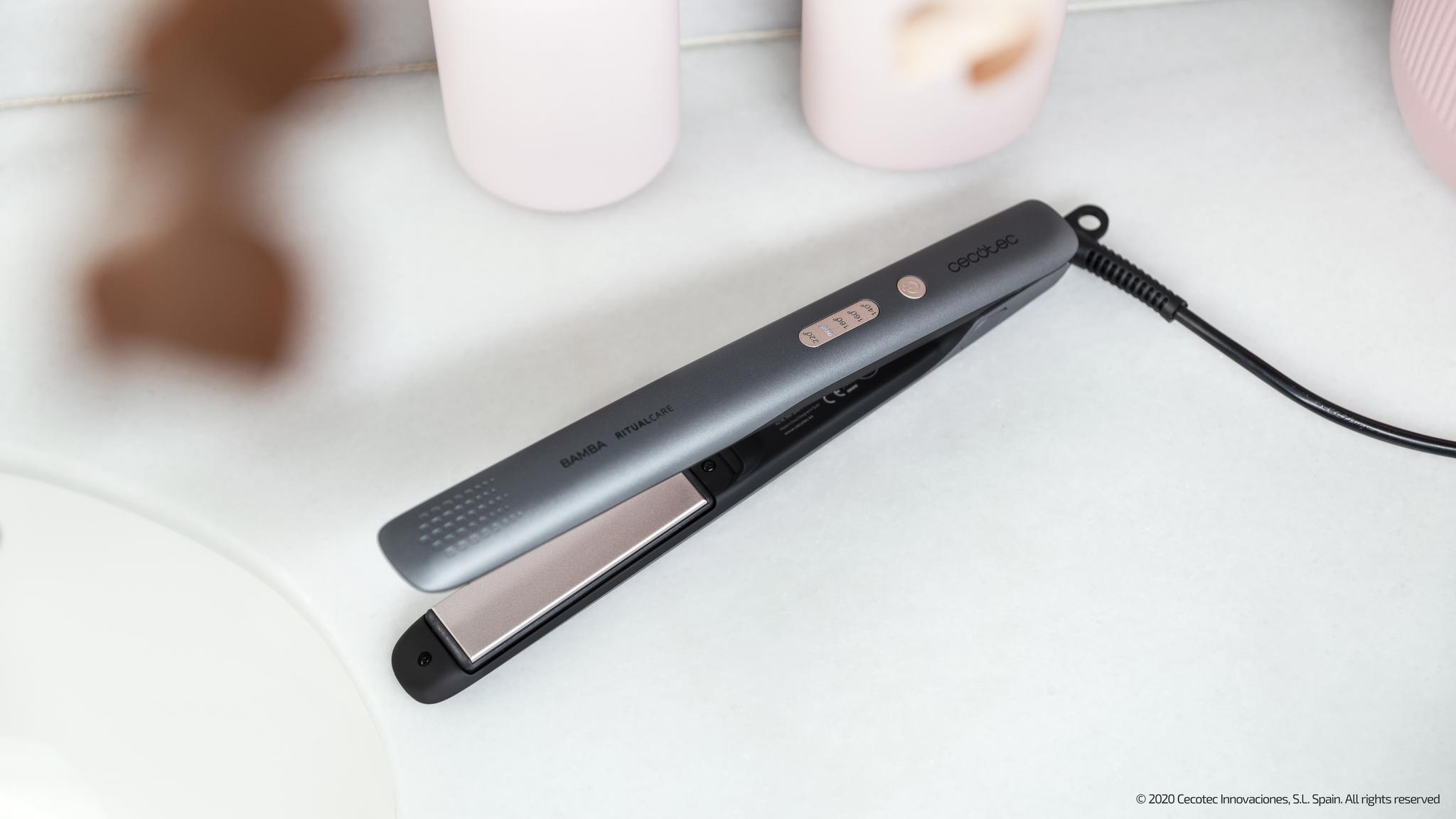 Prostownica na białej powierzchni obok produktów do pielęgnacji skóry.