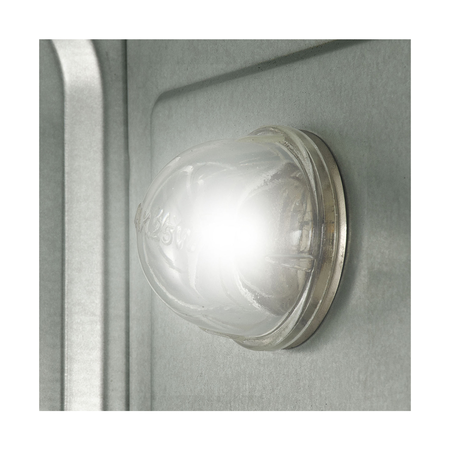 Un primo piano di una lampadina accesa all'interno di una copertura in vetro in un involucro metallico.