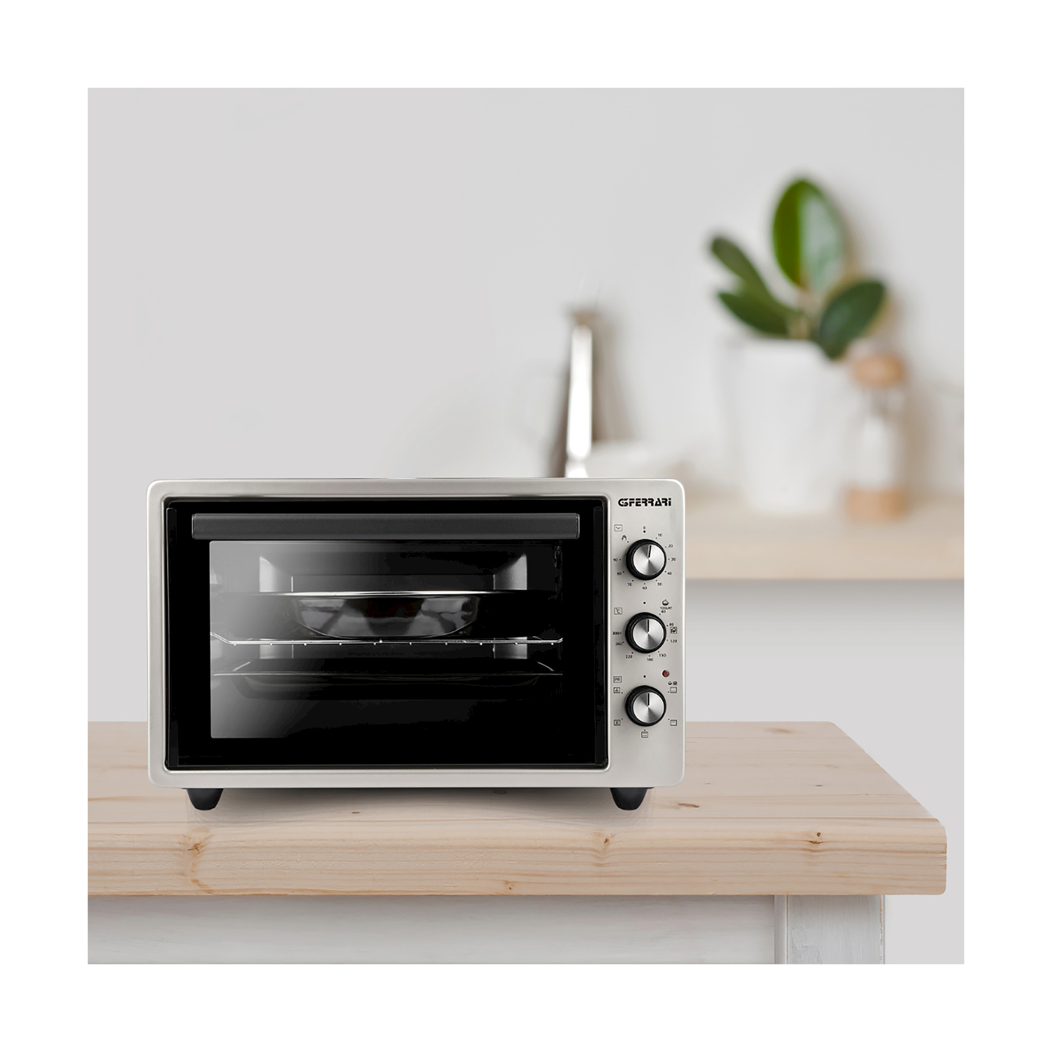 Un forno bianco su una superficie di legno. Ha comandi neri e una porta a vetri.