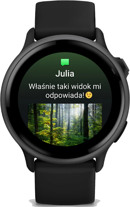 Czarny smartwatch Garmin wyświetlający wiadomość od Julii ze zdjęciem lasu.