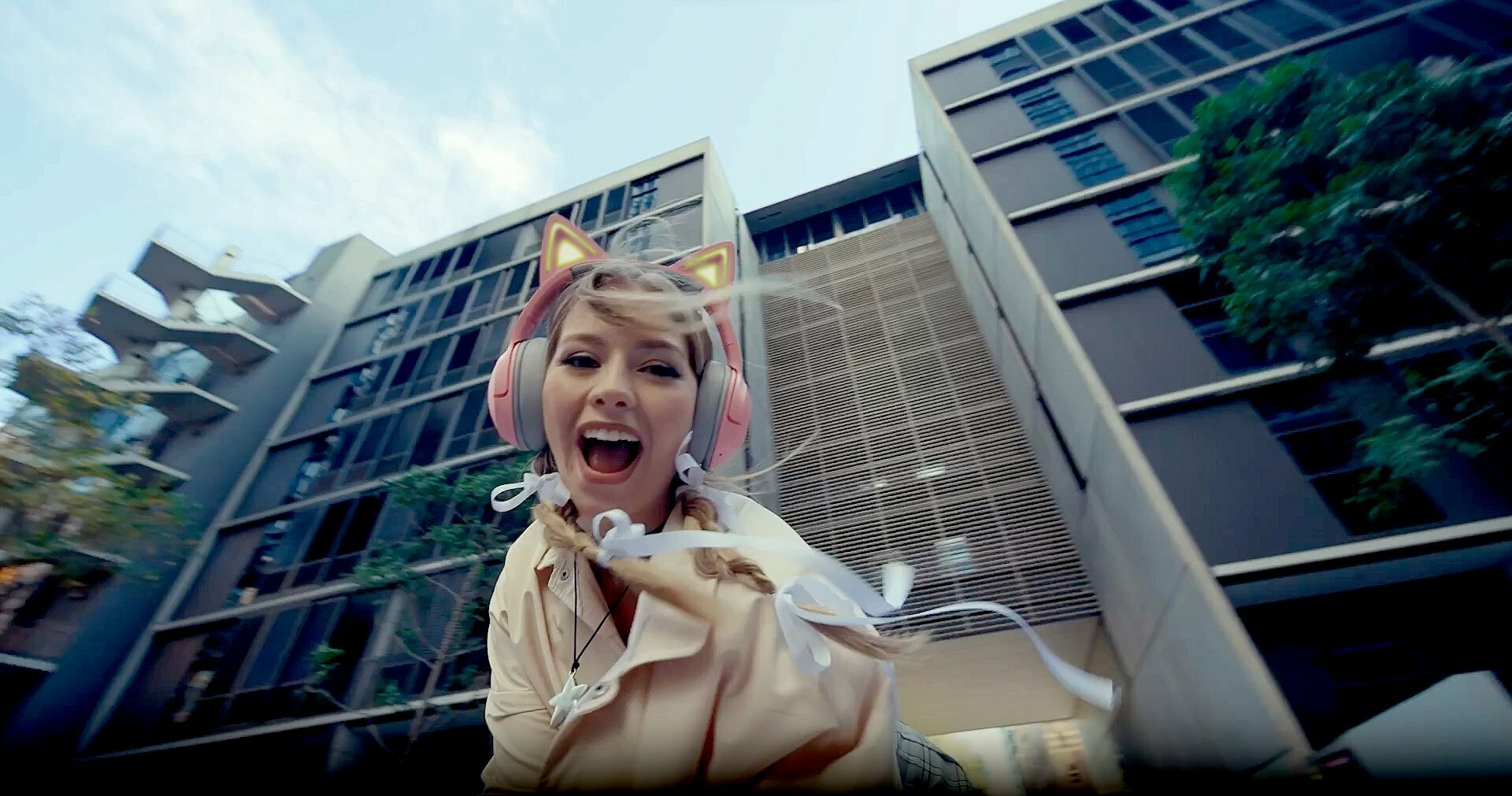 Młoda kobieta w słuchawkach z kocimi uszami pochyla się do przodu i krzyczy.