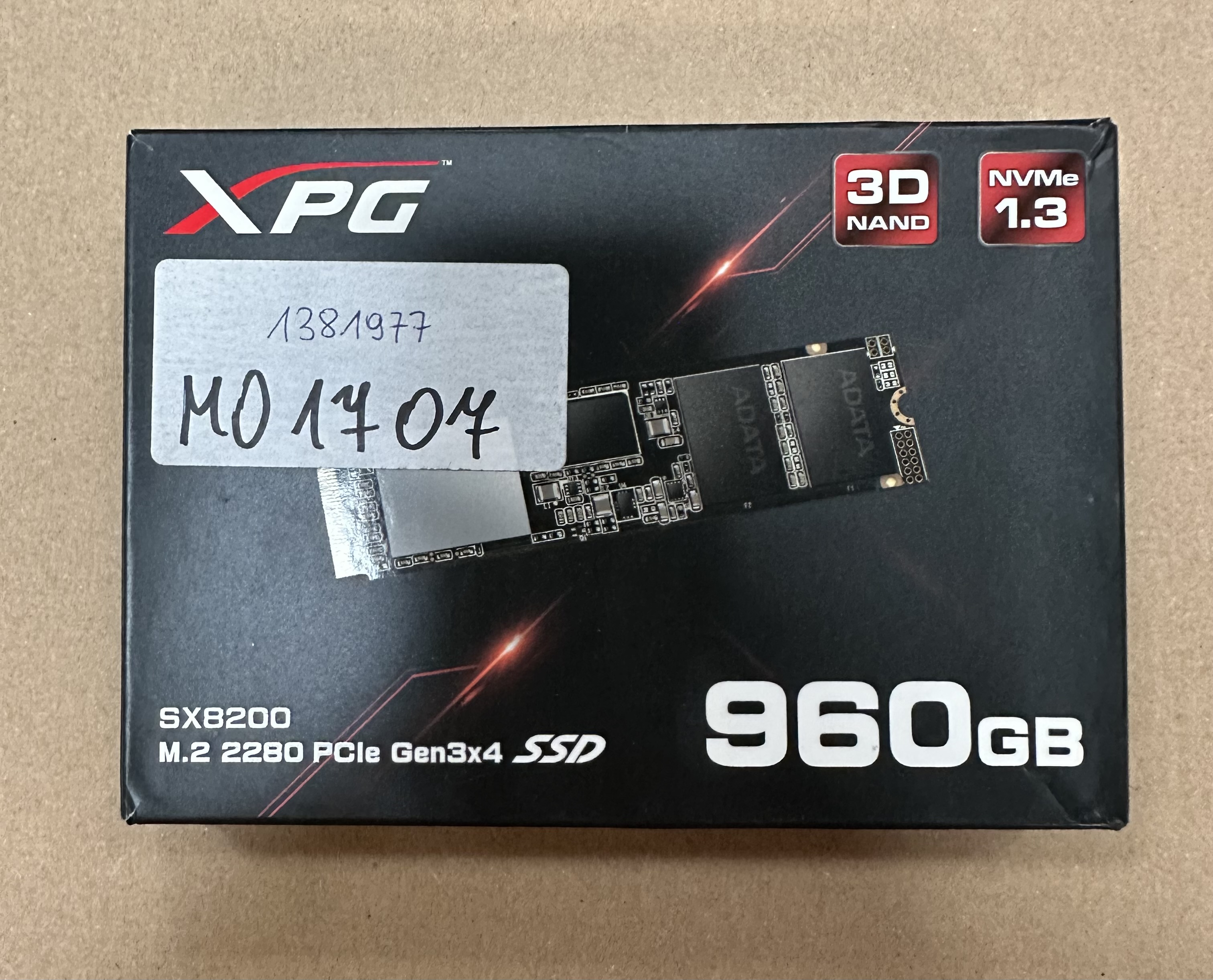 Czarne pudełko z etykietą i dyskiem SSD. Tekst: XPG, 960GB, SSD.