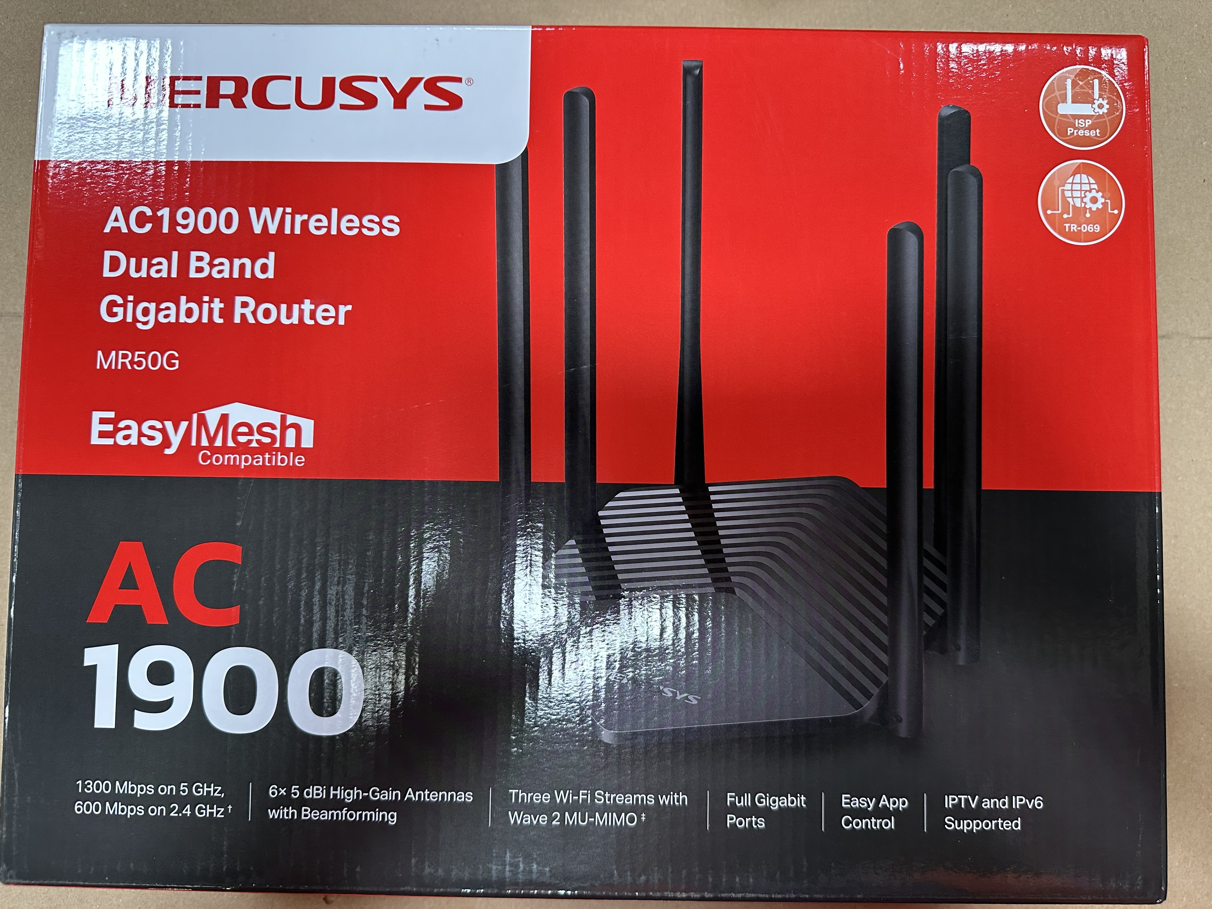 Pudełko routera Ercusys AC1900. Czarny grafik routera na czerwonym pudełku. Brązowe tło.