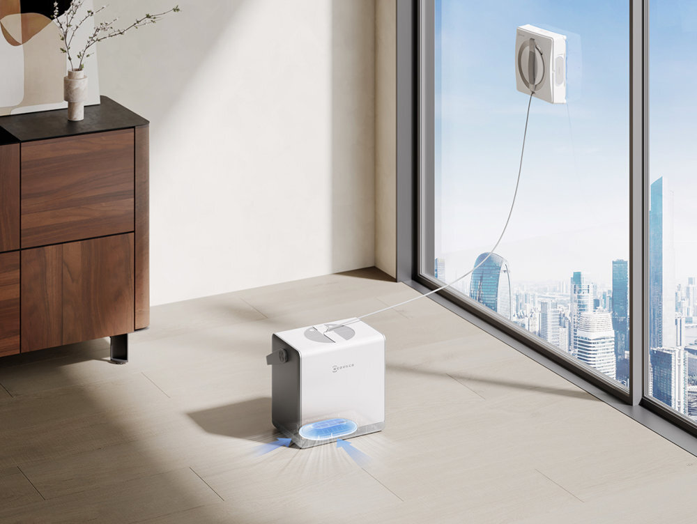 Robot do czyszczenia okien myjący duże okno, z miastem widocznym przez szybę. Jednostka bazowa na podłodze.