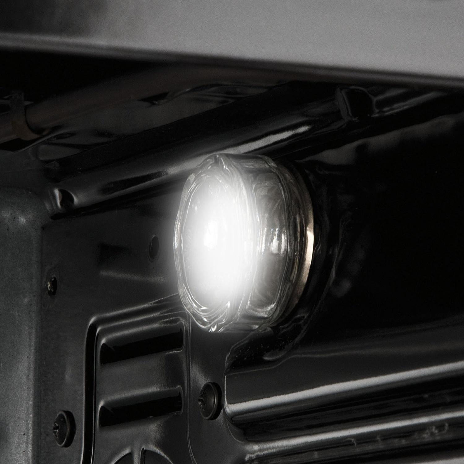 Luce brillante del forno all'interno di un vano forno scuro. La luce è rotonda e luminosa.