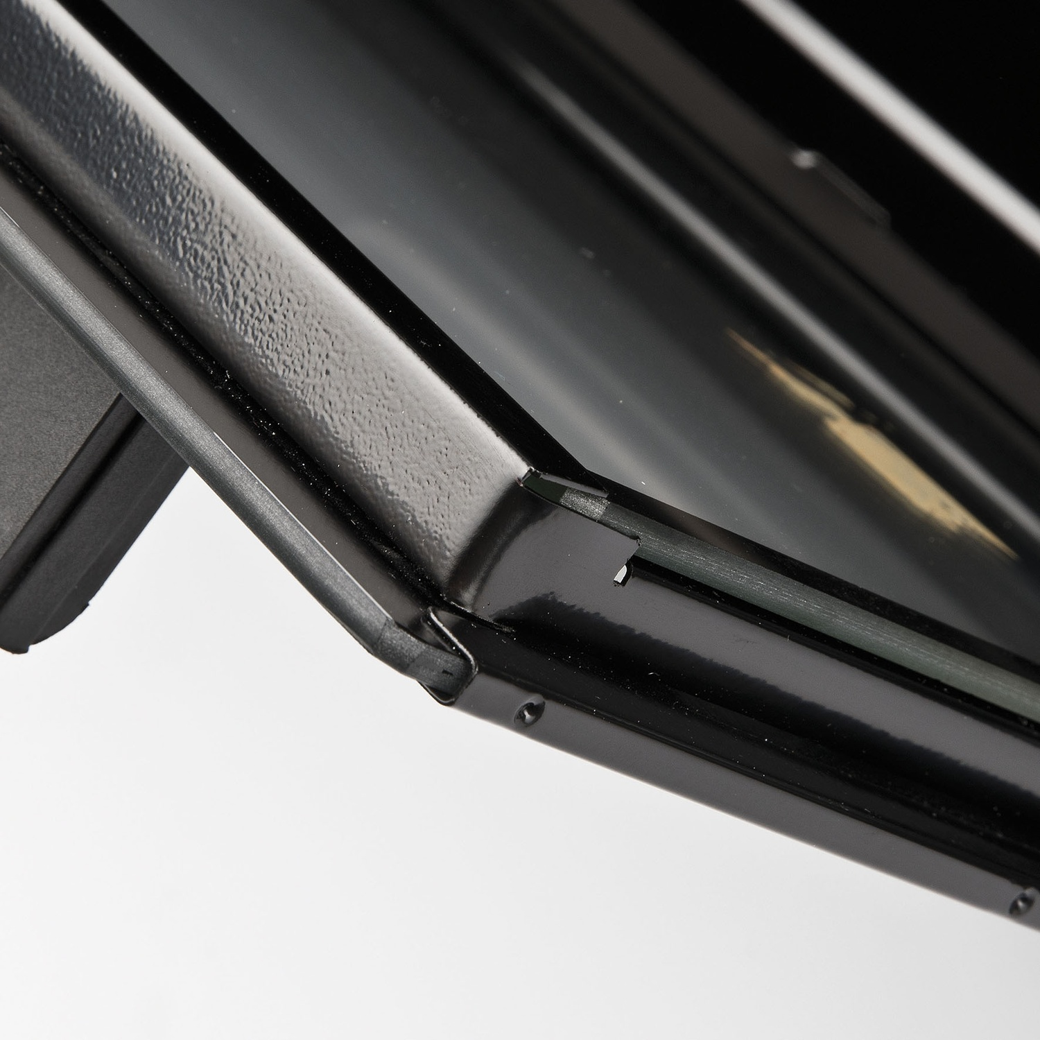 Primo piano del bordo del tetto di un'auto nera, che mostra le finiture e una vista parzialmente aperta.