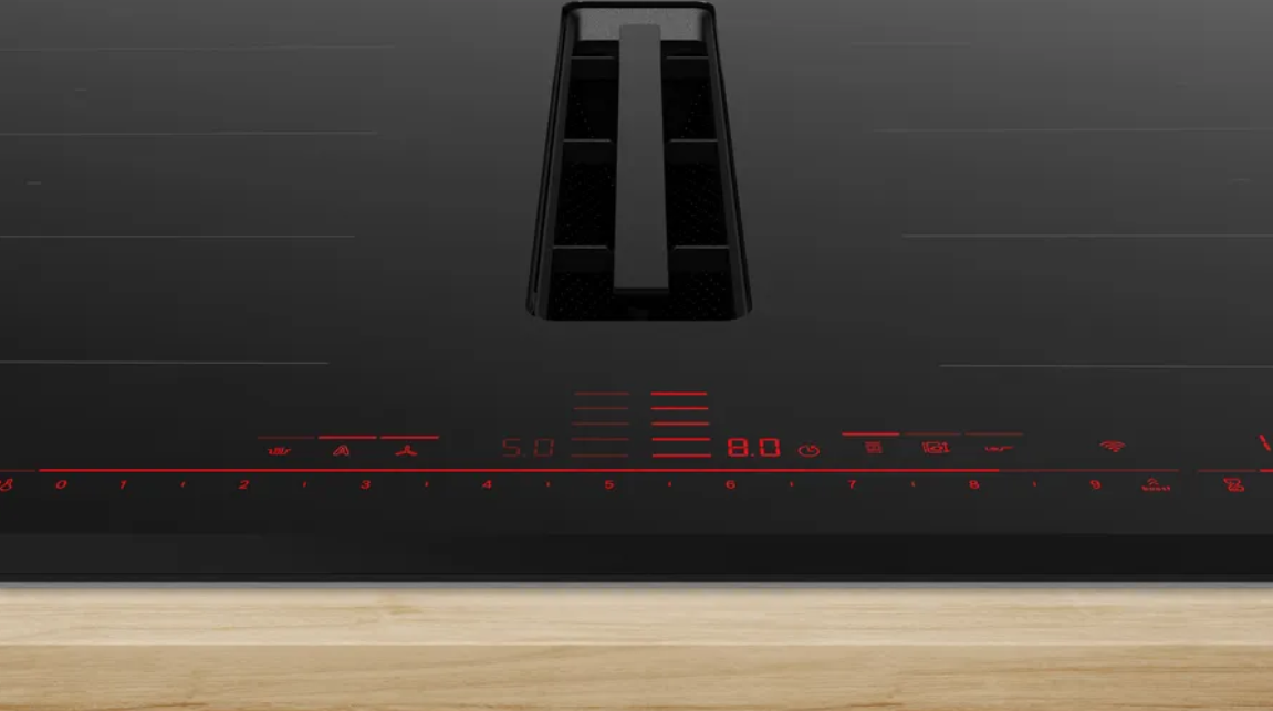 Primer plano de una placa de inducción negra con números rojos iluminados.