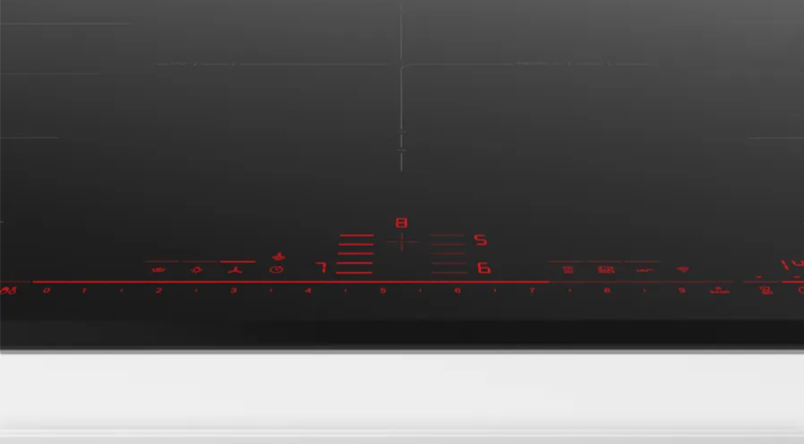 Primer plano de una encimera negra con controles y números digitales rojos.