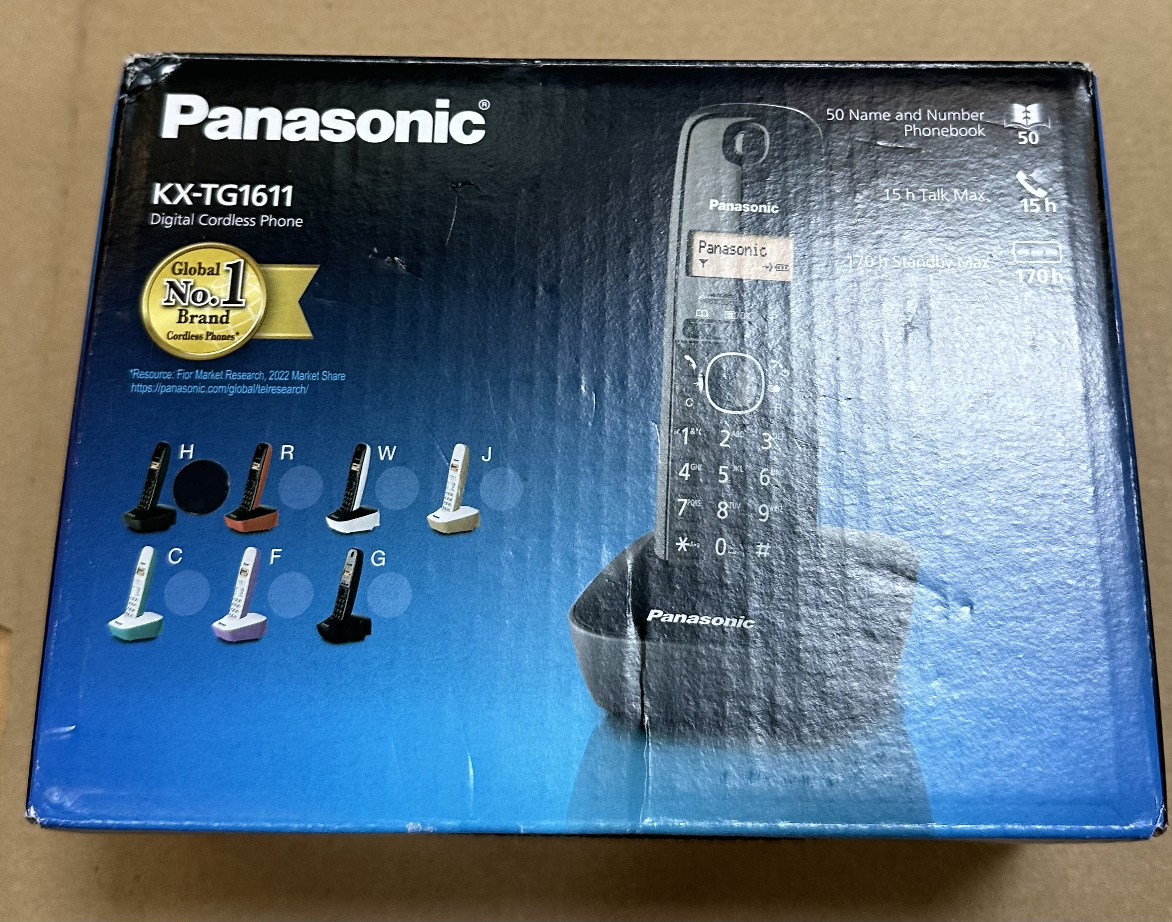 Niebieskie pudełko telefonu bezprzewodowego Panasonic KX-TG1611, z telefonem na nim.