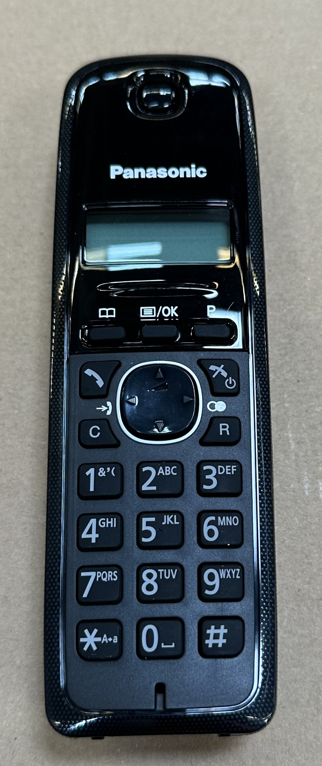 Czarny telefon bezprzewodowy Panasonic z przyciskami i małym ekranem.