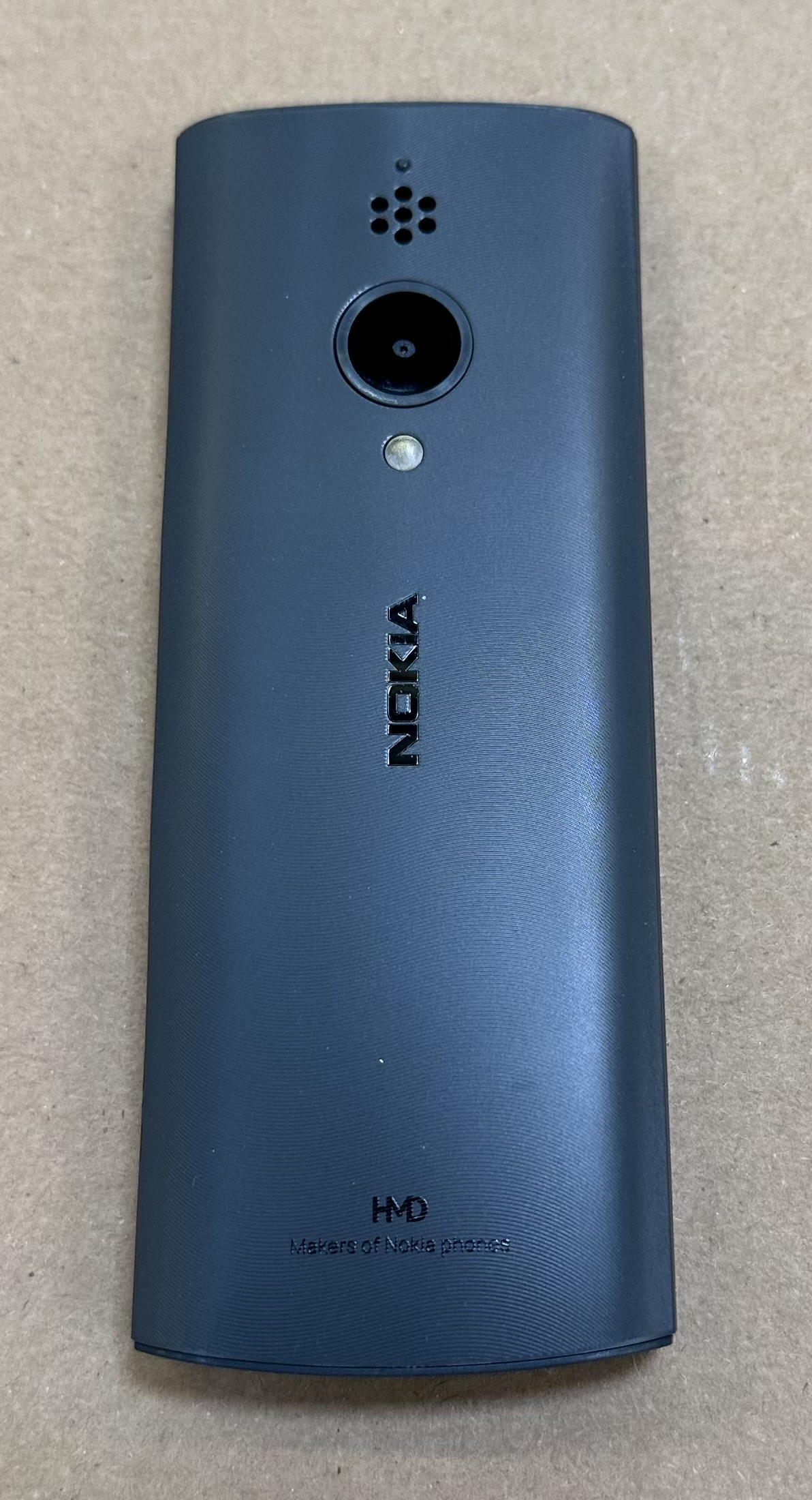 Telefon stacjonarny w kolorze ciemnoniebieskim, pokazujący tył z logo NOKIA i aparatem.
