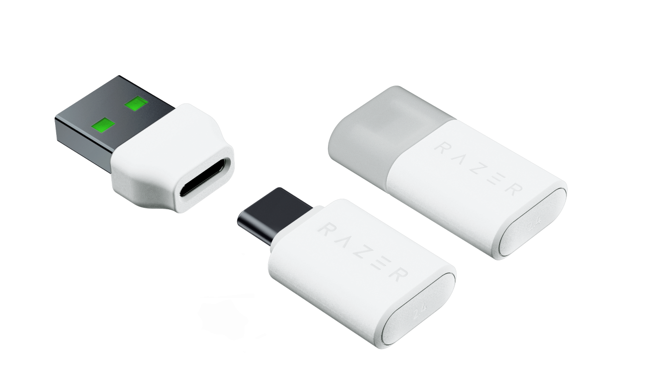 Trzy białe urządzenia USB Razer, dwa z napisem RAZER, na czarnym tle.