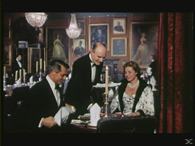 Eine Szene in einem Restaurant mit Personen, einem Kellner und Gemälden.