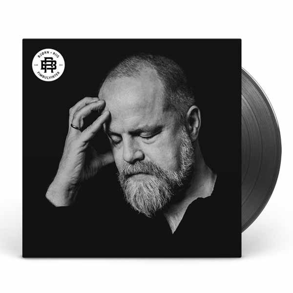 Schwarz-Weiß-Foto eines Mannes mit Bart, der nach unten schaut. Vinyl-Schallplatte rechts.