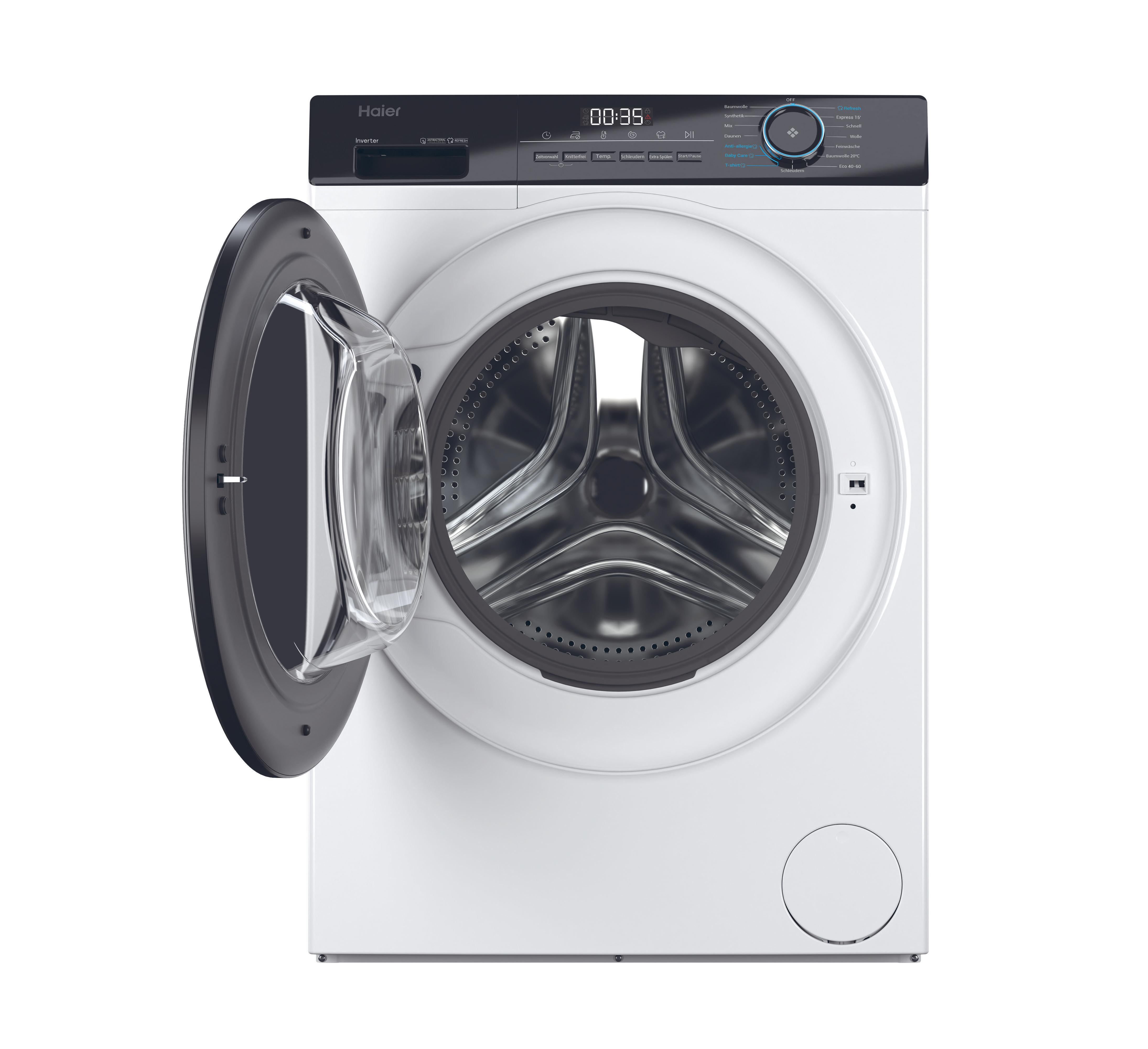 Eine weiße Haier Waschmaschine, die Tür geöffnet, die Trommel zeigend. Das Bedienfeld oben.