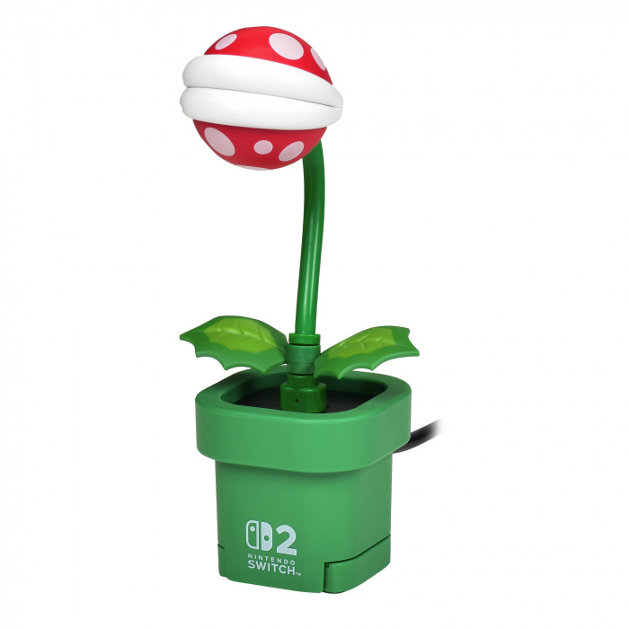 Lampa Super Mario Piranha Plant, zielona podstawa, czerwona i biała głowa, zielona łodyga. Jest podłączona do konsoli Nintendo Switch.