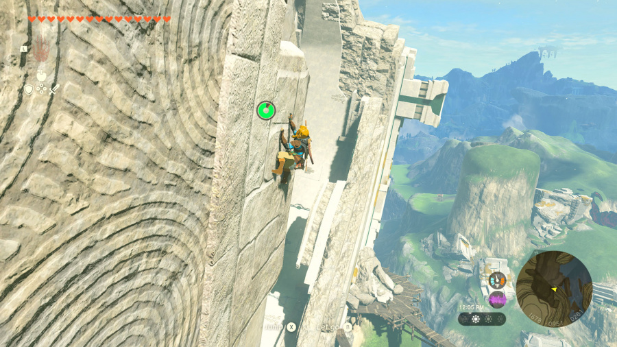 Postać wspina się po kamiennej ścianie w grze wideo. Widoczny zielony wskaźnik zdrowia.