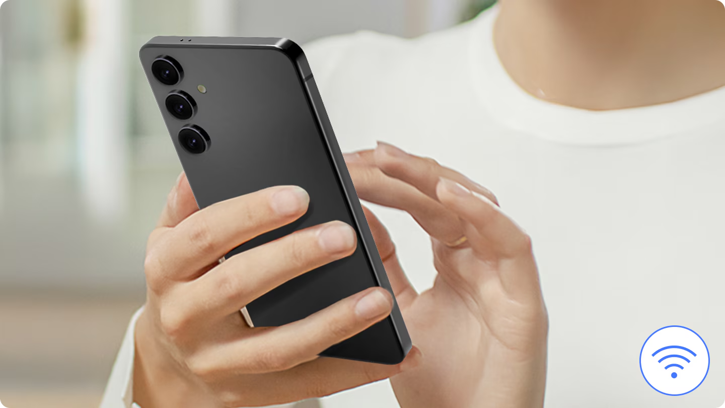 Egy személy egy fekete okostelefont tart, három kamerával. A sarokban egy WiFi ikon látható.