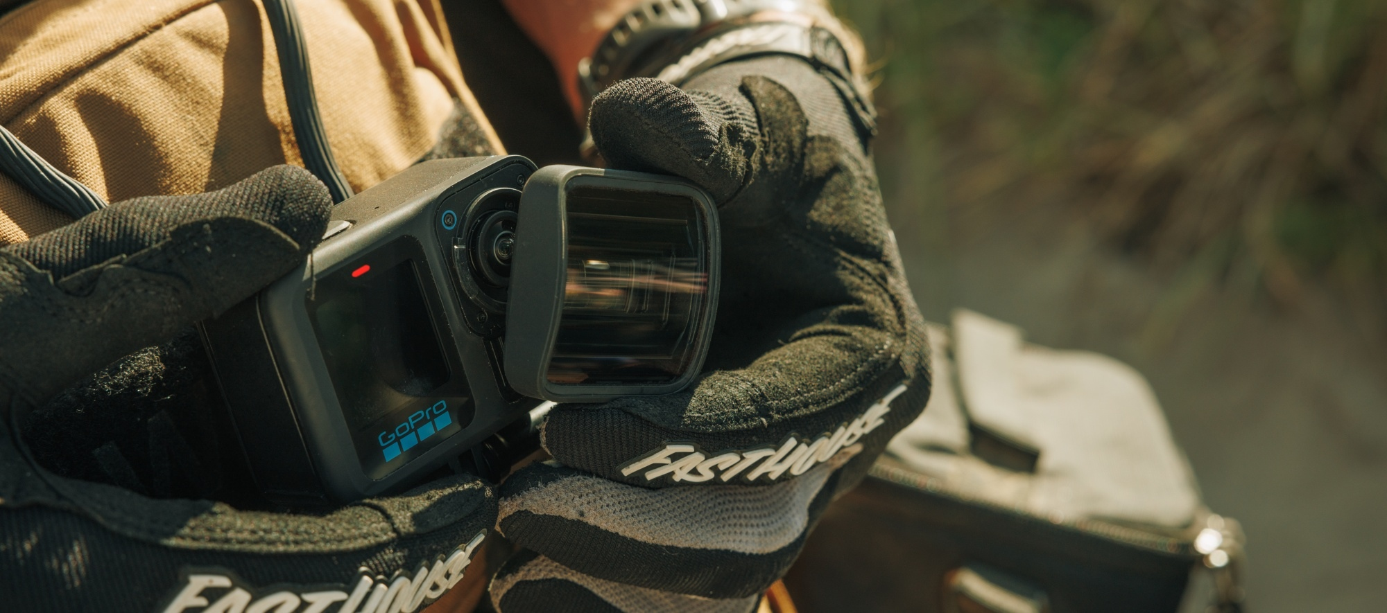 Person hält GoPro-Kamera mit Objektiv in der Hand.