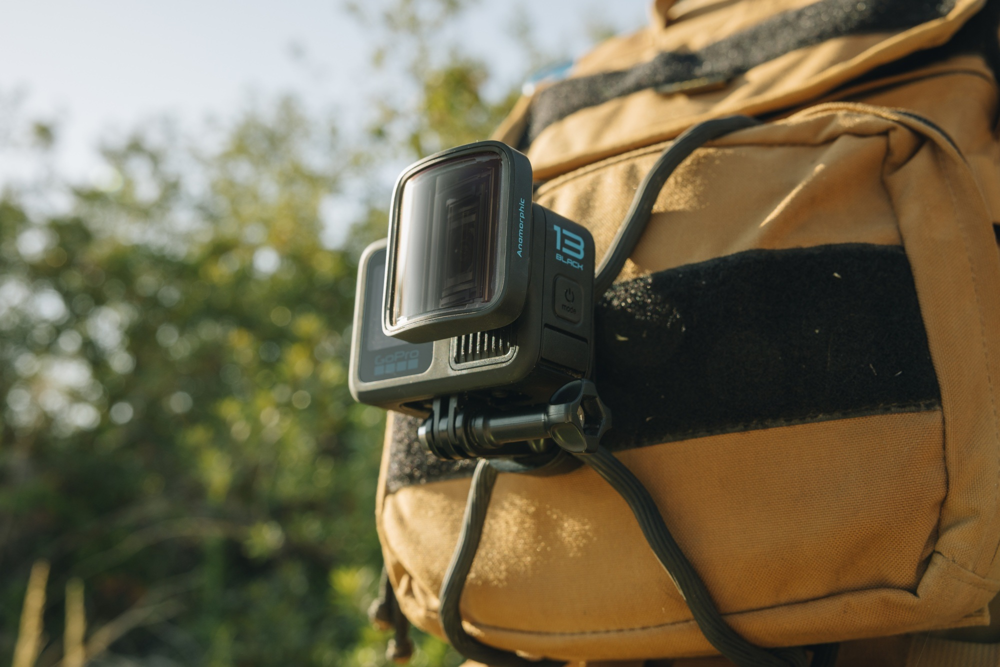 Eine GoPro-Kamera, die an einem Rucksackriemen befestigt ist. Sie ist schwarz, montiert und nach draußen gerichtet.