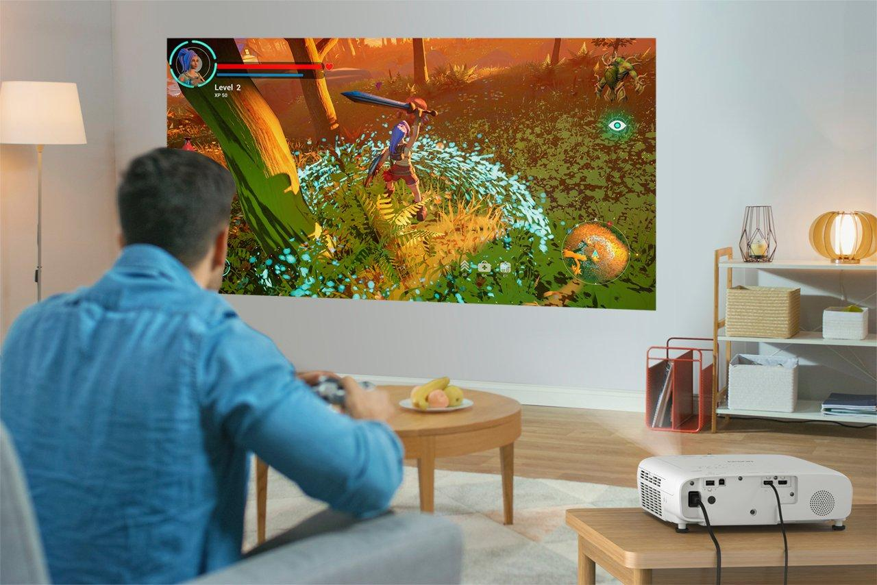 Ein Mann spielt ein Videospiel auf einer projizierten Leinwand.