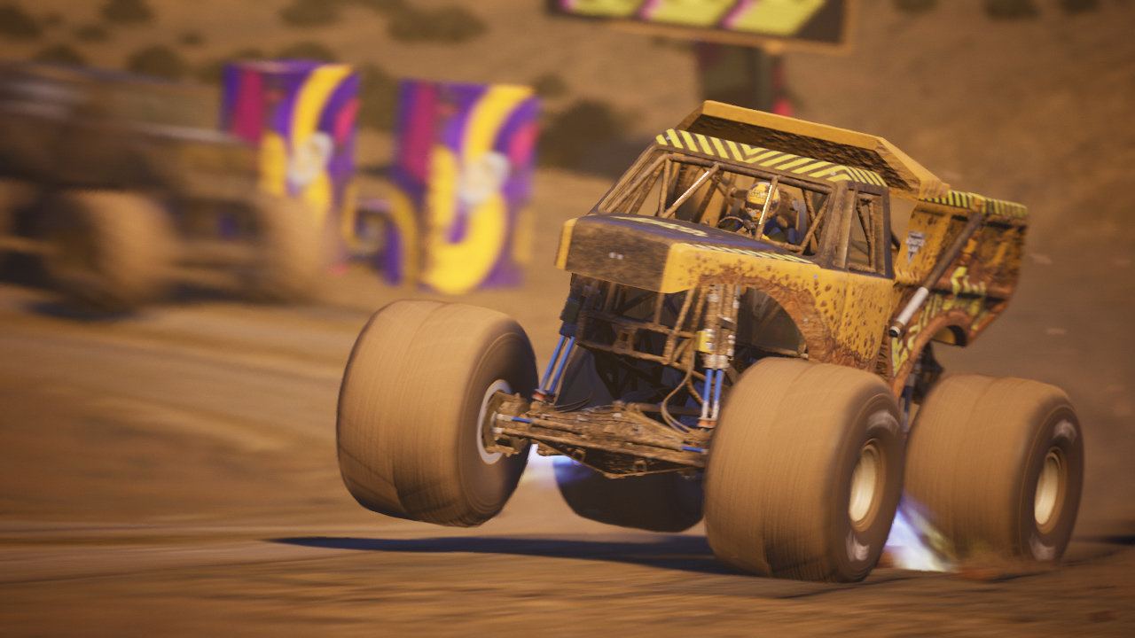 Un monster truck giallo che corre su una pista sterrata.
