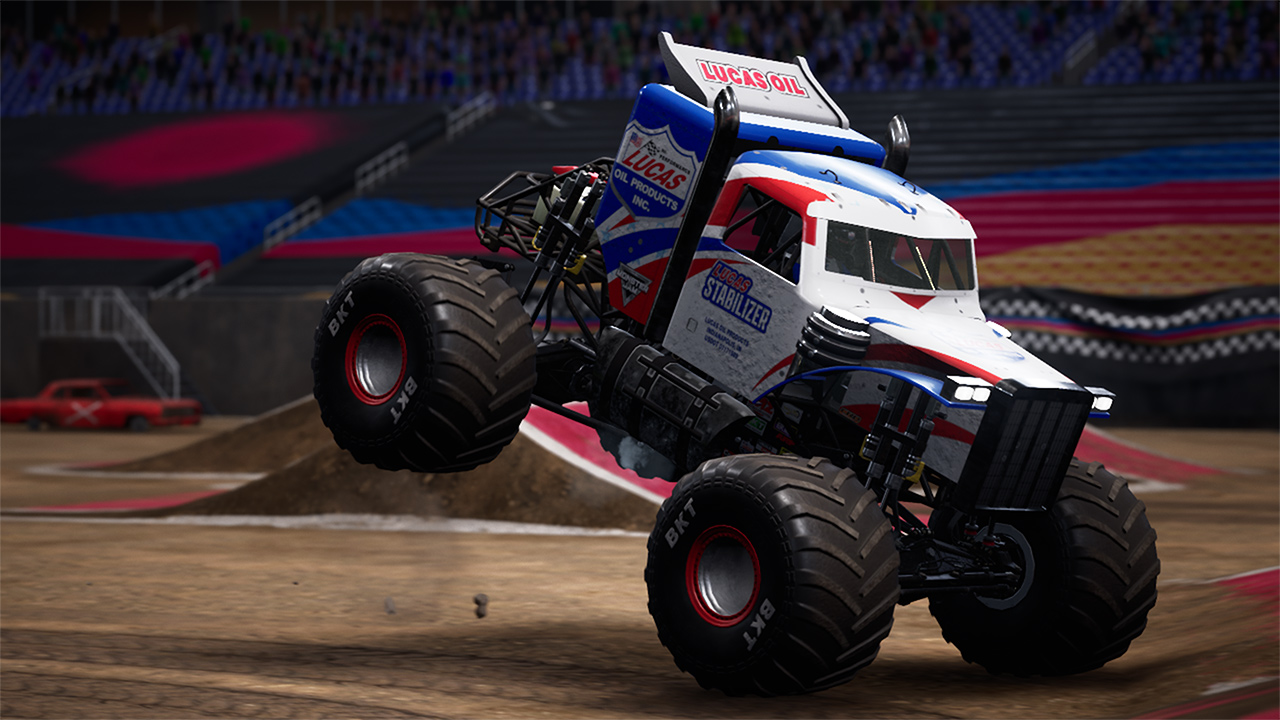 Un monster truck in uno stadio, che salta in aria. Il camion ha un design a bandiera britannica.