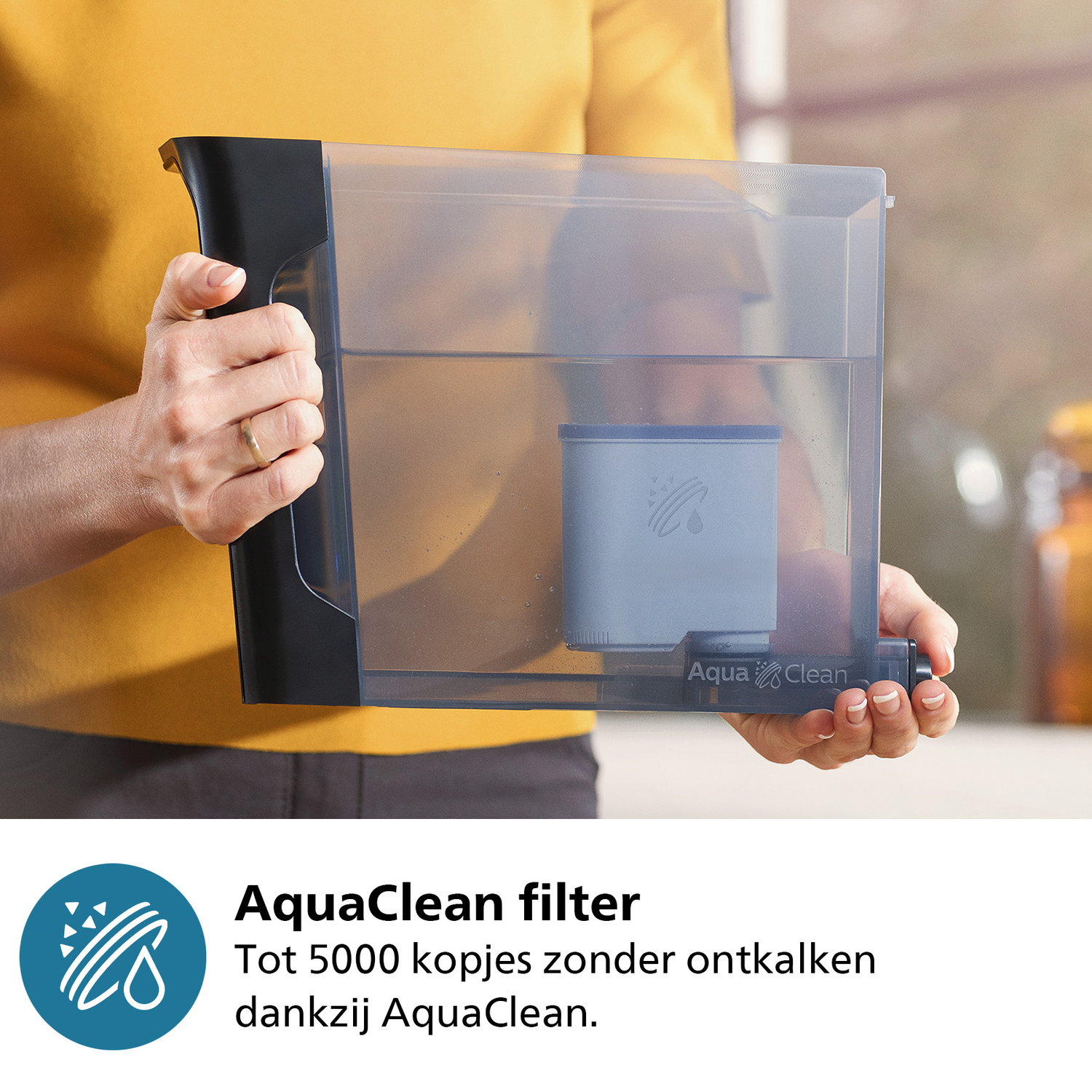Een persoon die een doorzichtige watertank vasthoudt met een blauw filter erin, met tekst over het AquaClean filter.