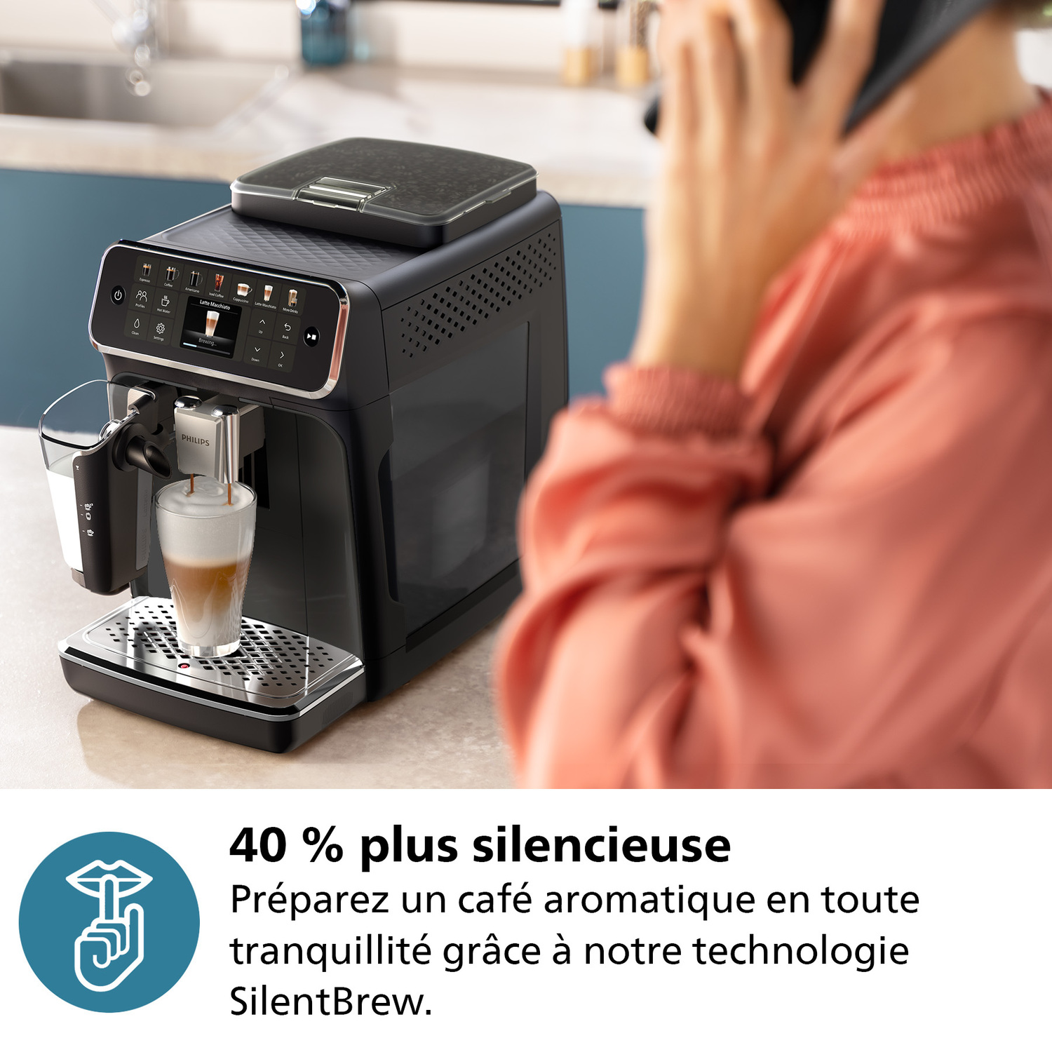 Une femme parle au téléphone et une machine à café distribue du café dans un verre.