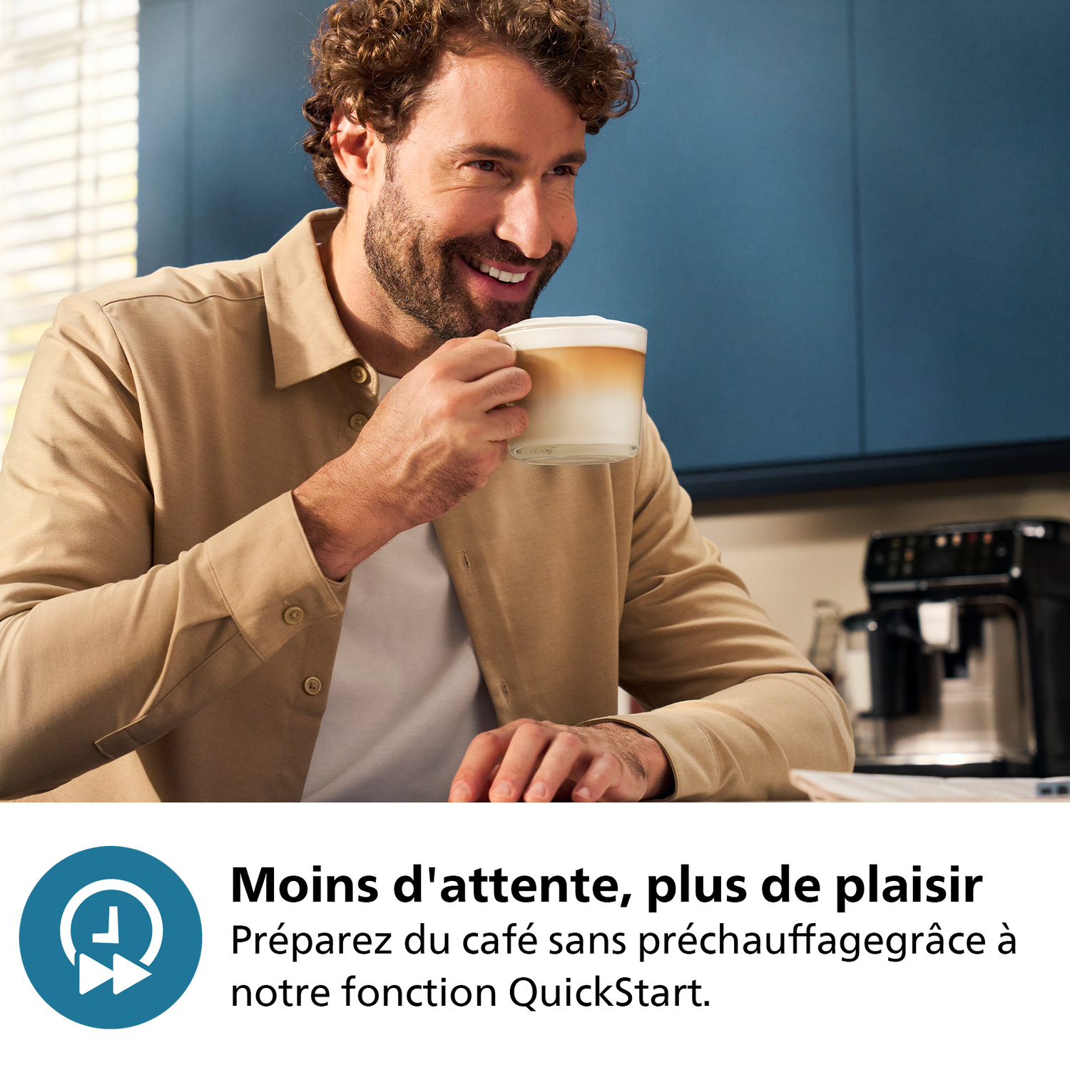 Homme souriant avec tasse à café, machine à café en arrière-plan.