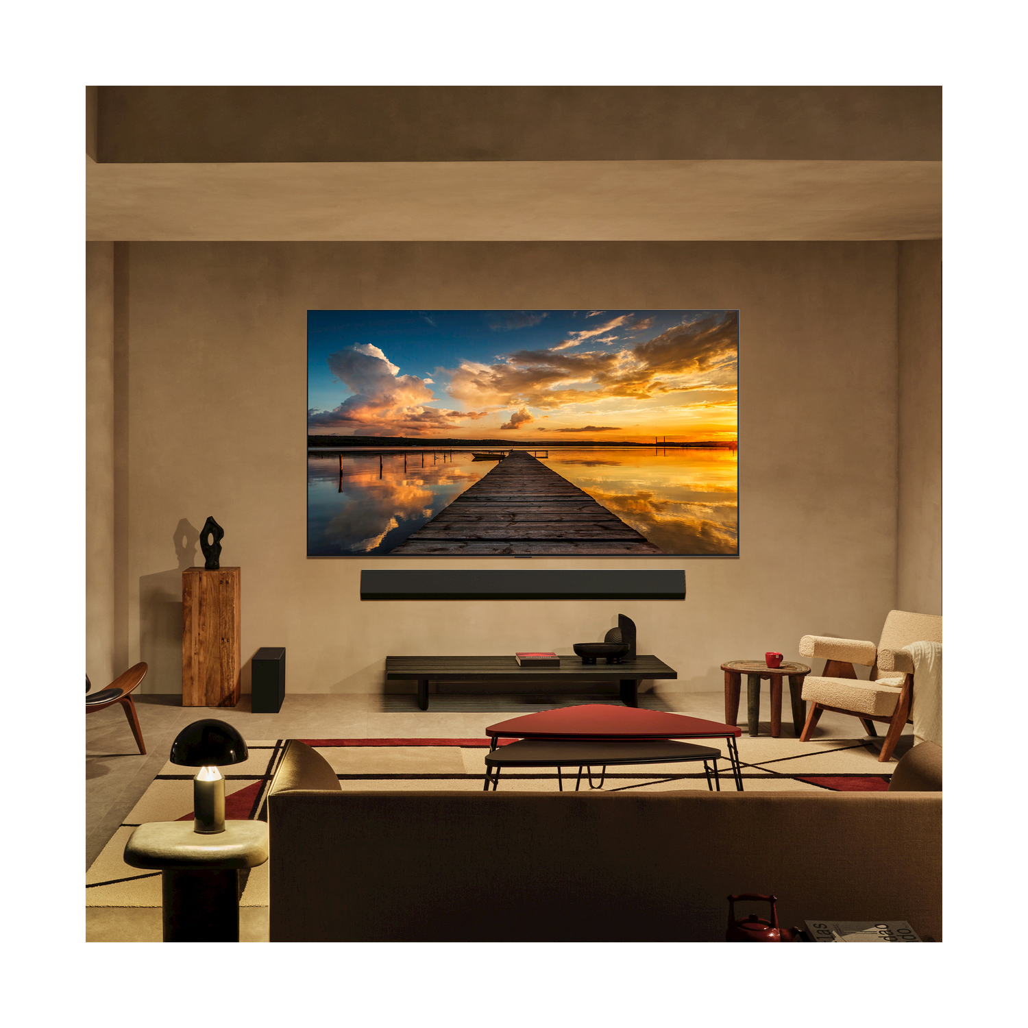 Soggiorno con una grande TV che mostra una scena del tramonto, con soundbar e design moderno.