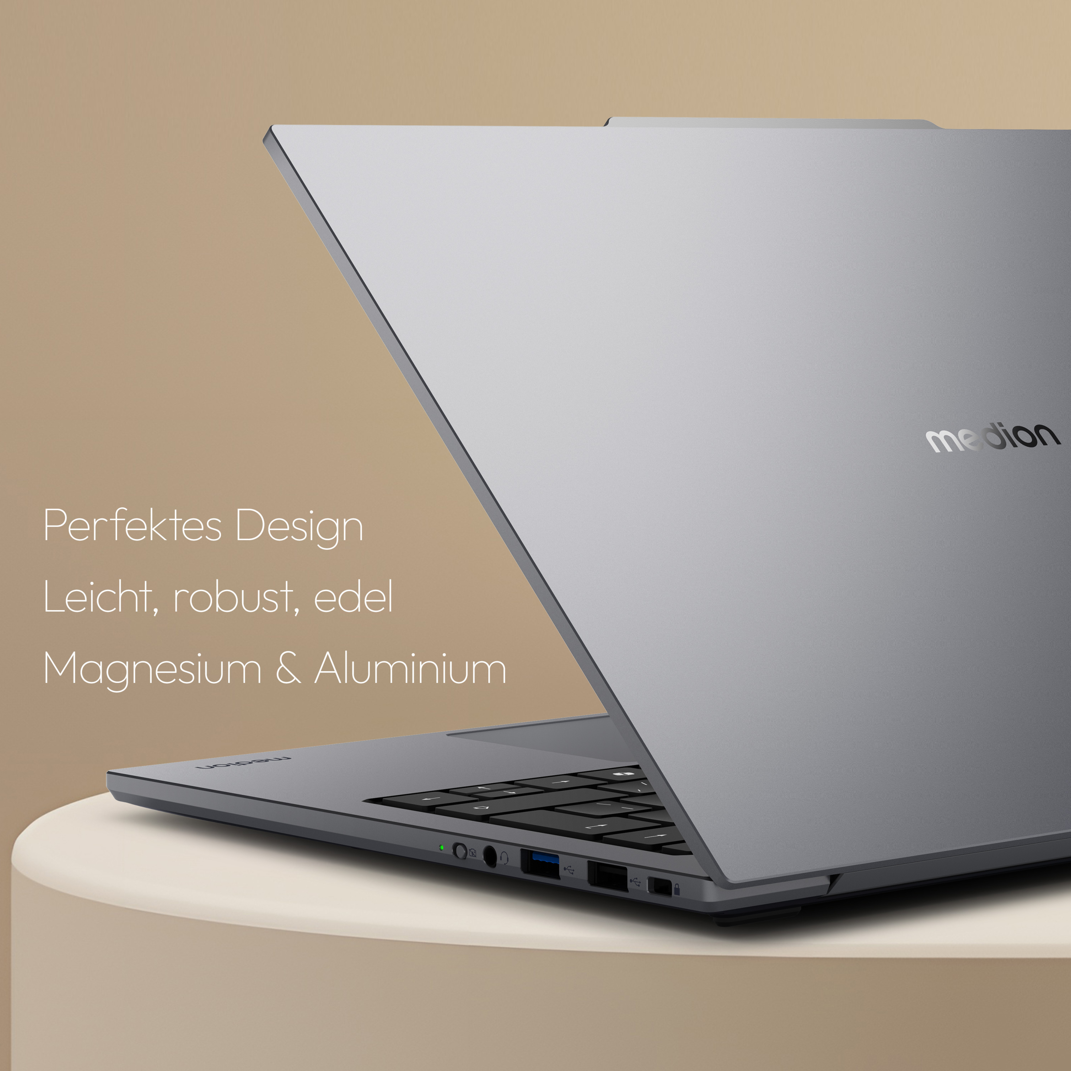 Ein silberner Laptop auf einer beigen Oberfläche, geöffnet, um die Tastatur zu zeigen. Das Medion-Logo ist sichtbar.