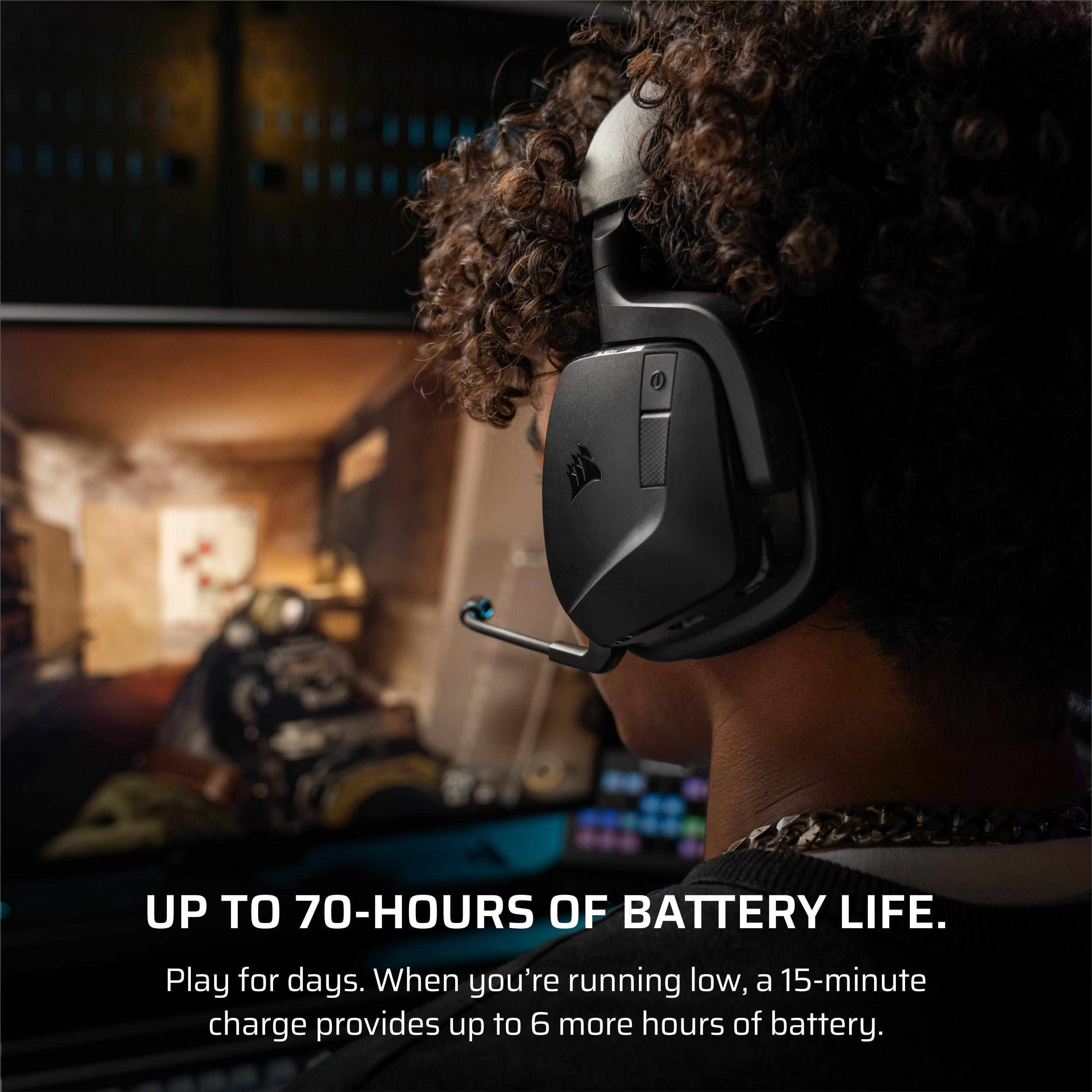Eine Person mit einem schwarzen Headset spielt ein Spiel, im Hintergrund ein Monitor.