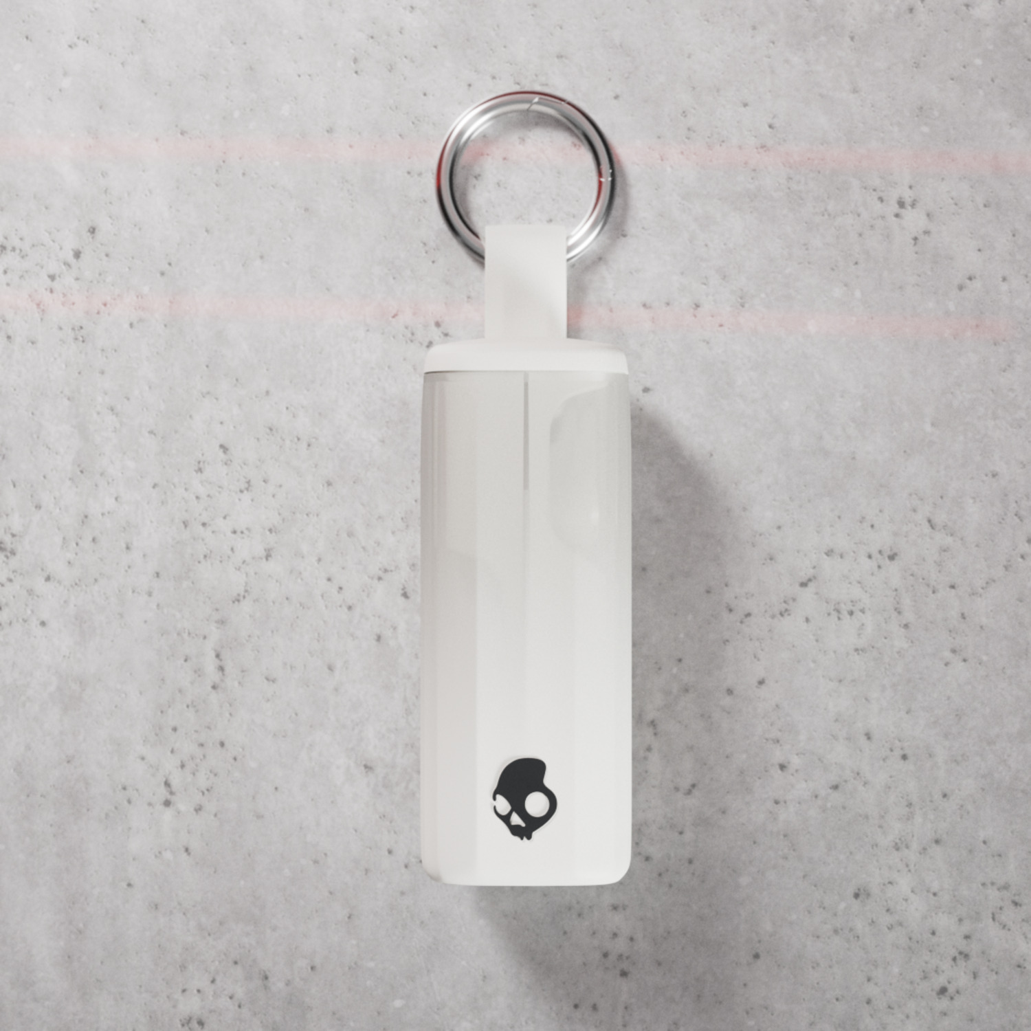 Weißes Skullcandy-Kopfhörer-Etui, das mit einem Ring an einer Wand hängt.