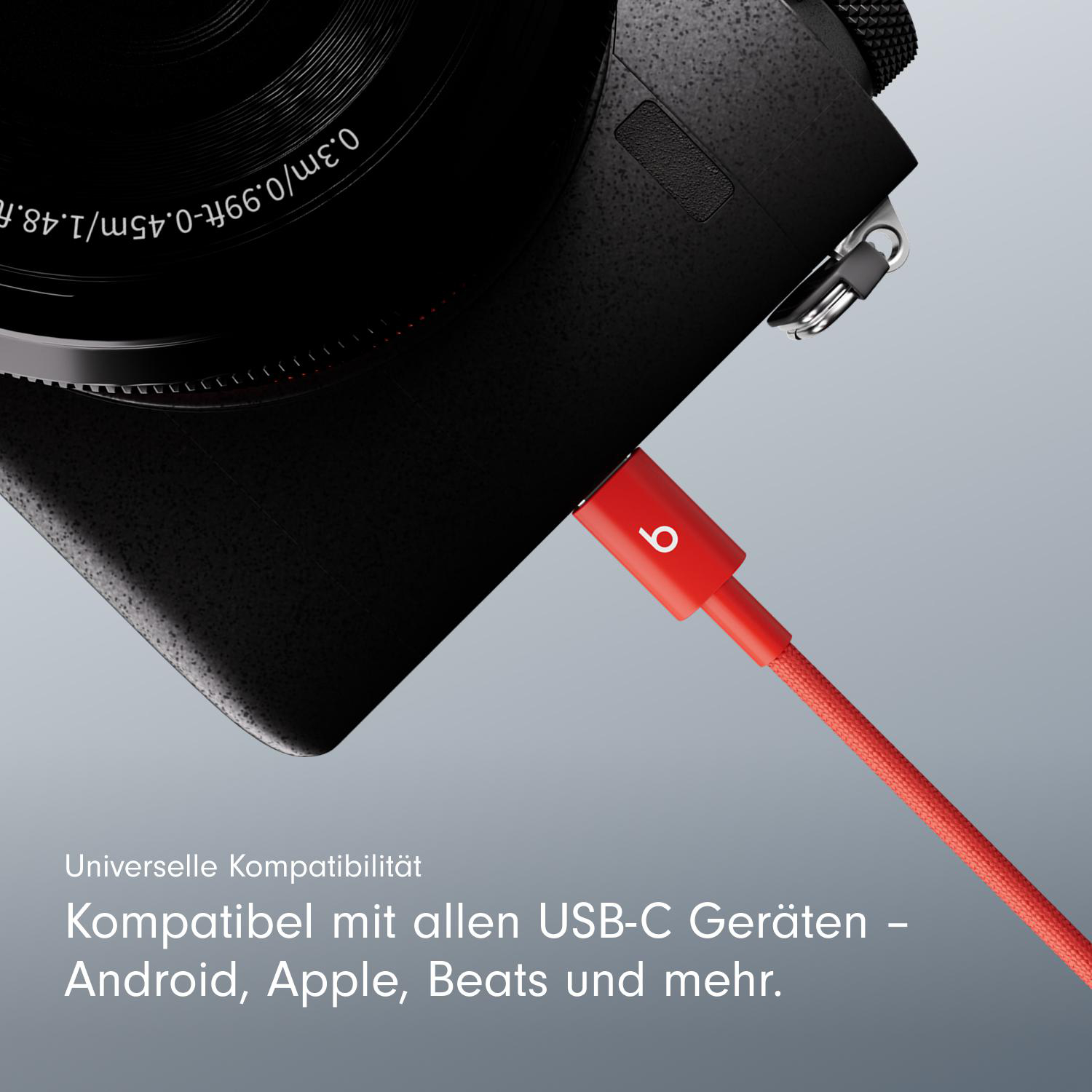 Eine schwarze Kamera mit einem roten Ladekabel, das eingesteckt ist, mit 'b' Logo.
