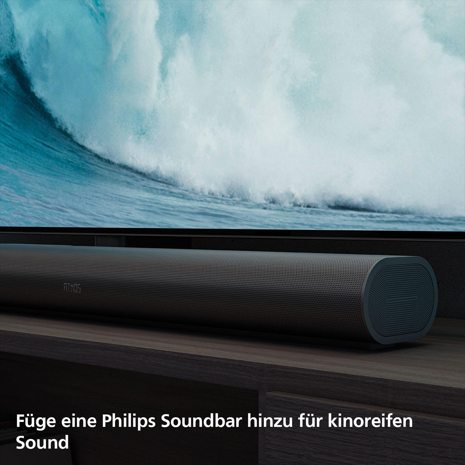 Eine Soundbar steht unter einem Fernseher. Ein stürmisches Meer ist auf dem Bildschirm zu sehen.