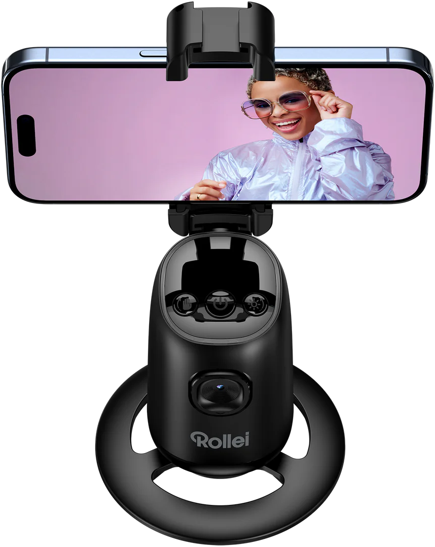 Person hält Telefon in Selfie-Stick, lächelt.