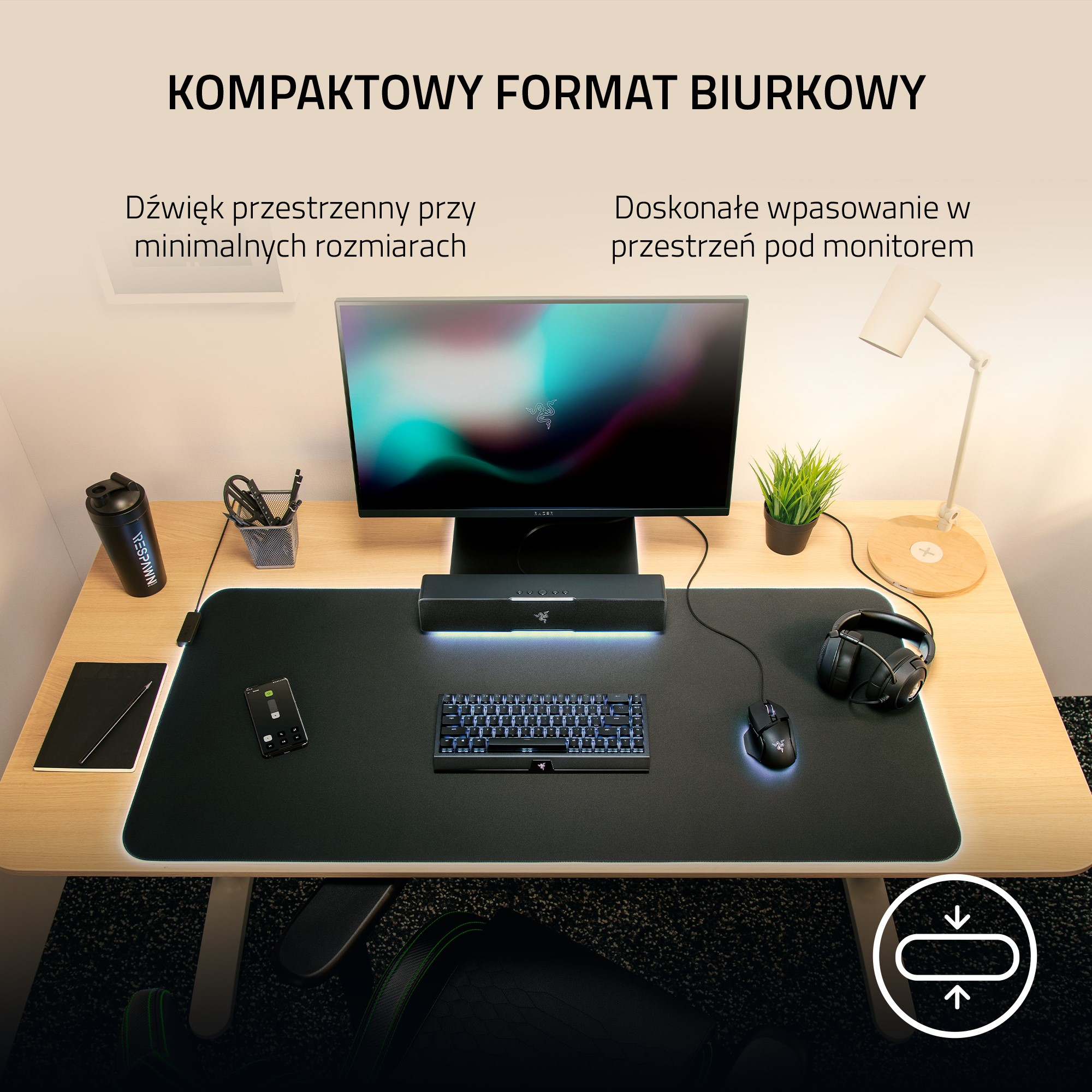 Konfiguracja biurka z monitorem, klawiaturą, myszą i innymi przedmiotami na czarnej macie.