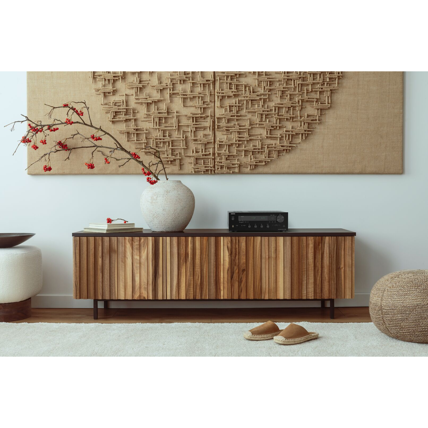 Wooden cabinet with decor and a vase of flowers.