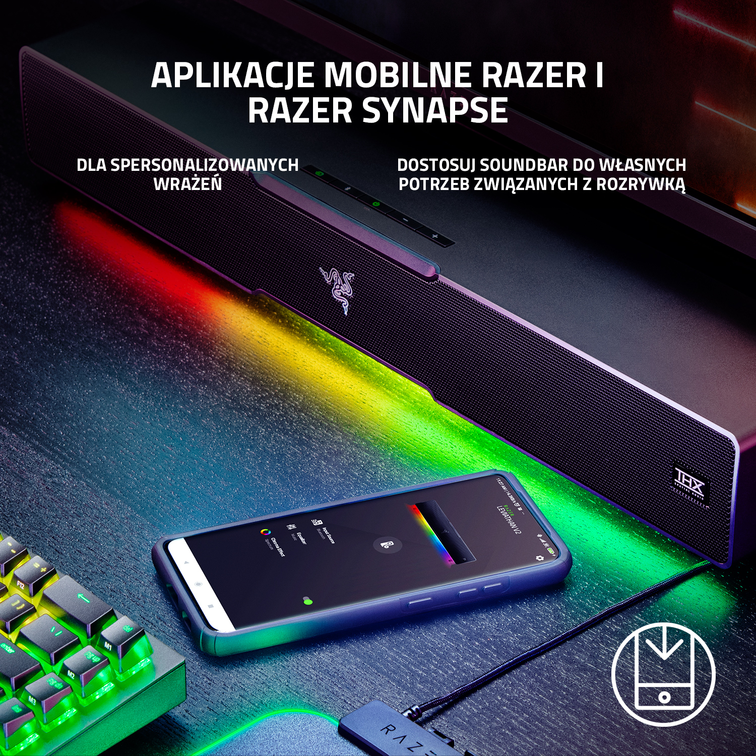 Soundbar Razer ze smartfonem wyświetlającym aplikację Razer Synapse i klawiaturą na biurku.