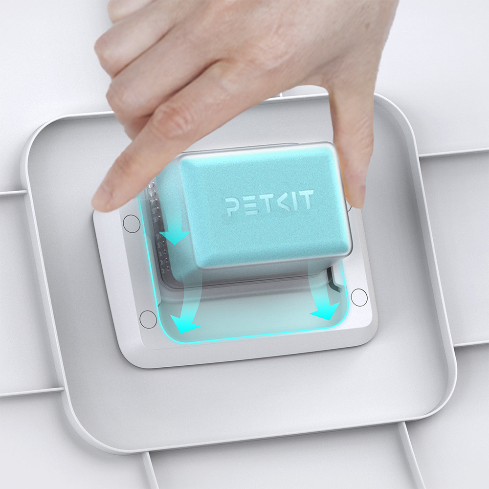 Eine Hand platziert ein blaues Petkit-Produkt in eine weiße Basis mit Pfeilen.