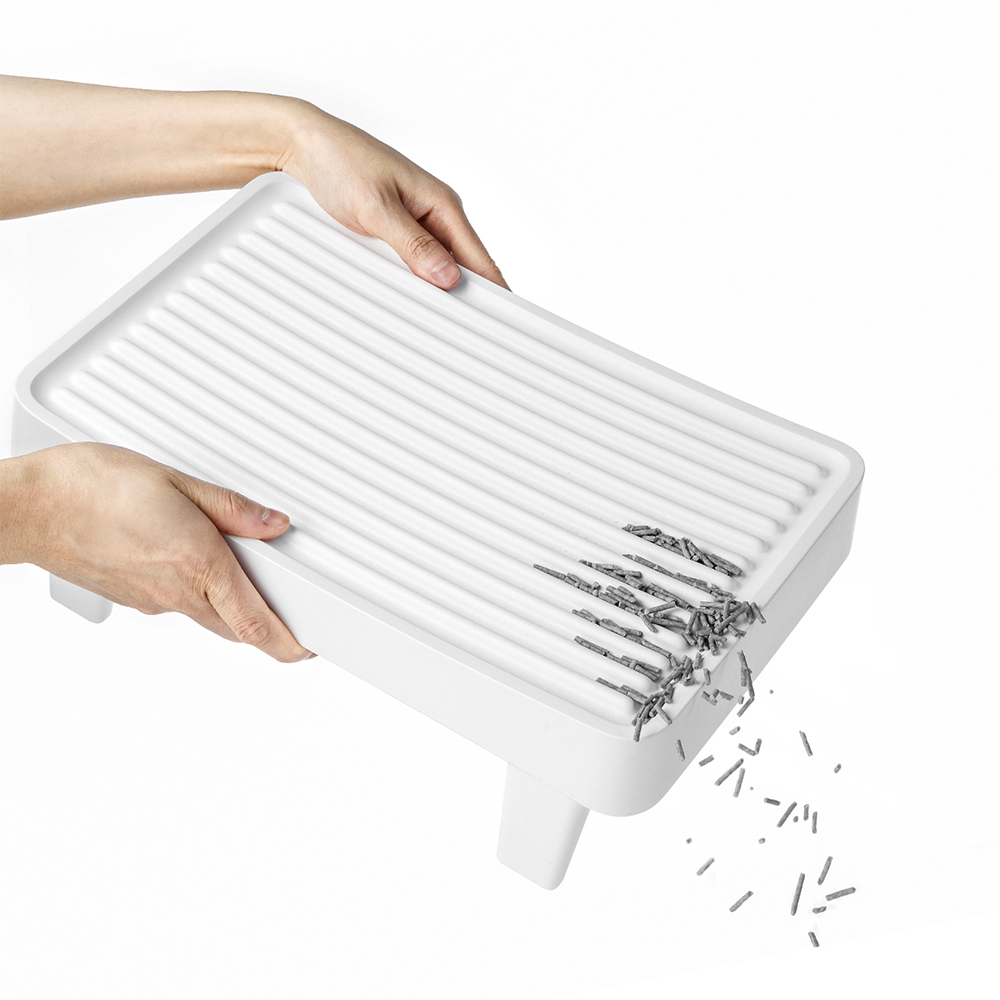 Mani che tengono uno scolapiatti bianco con alcuni pioli grigi e gocce d'acqua.
