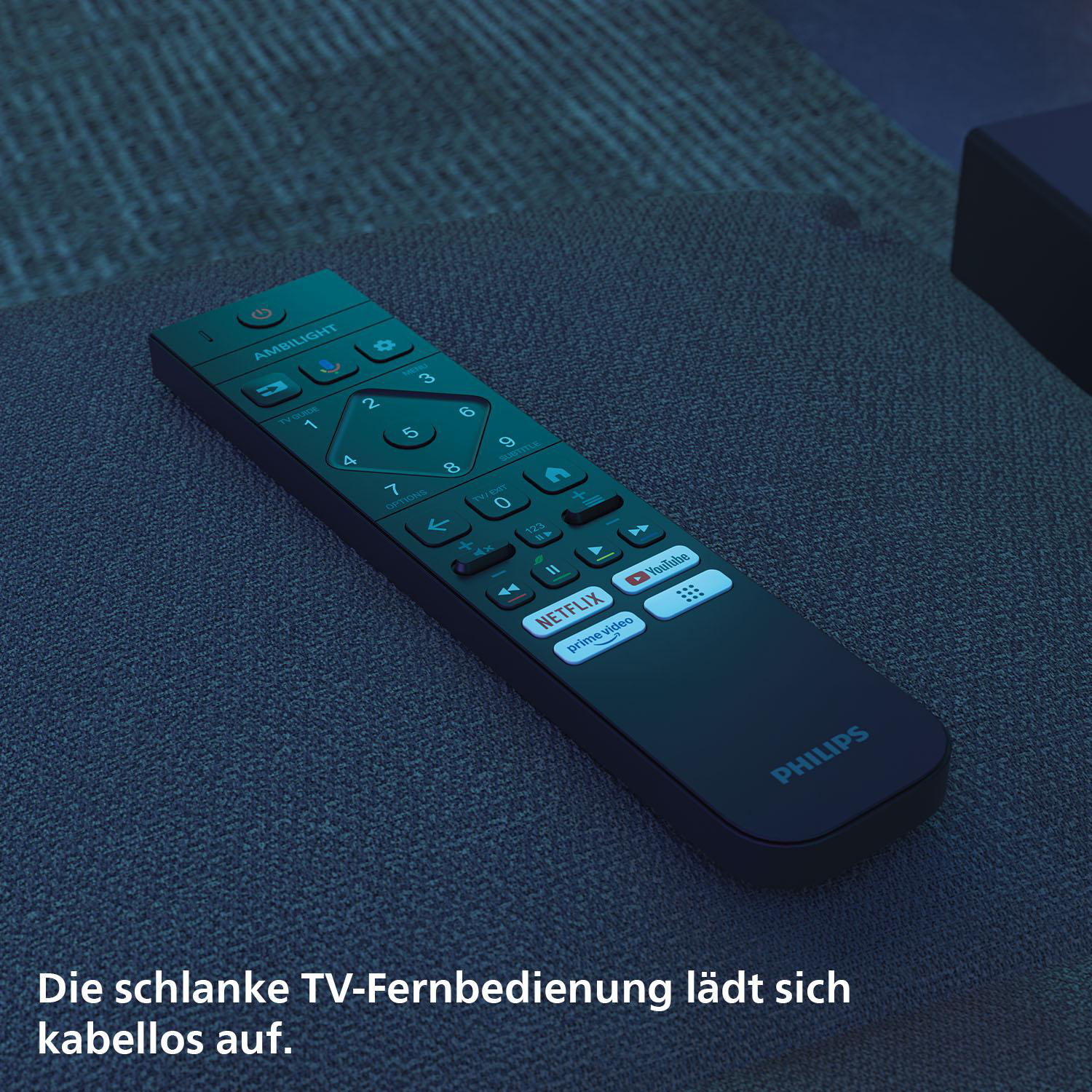 Schwarze TV-Fernbedienung auf grauem Sofa. Die Fernbedienung hat Knöpfe mit Zahlen, Symbolen und Wörtern.