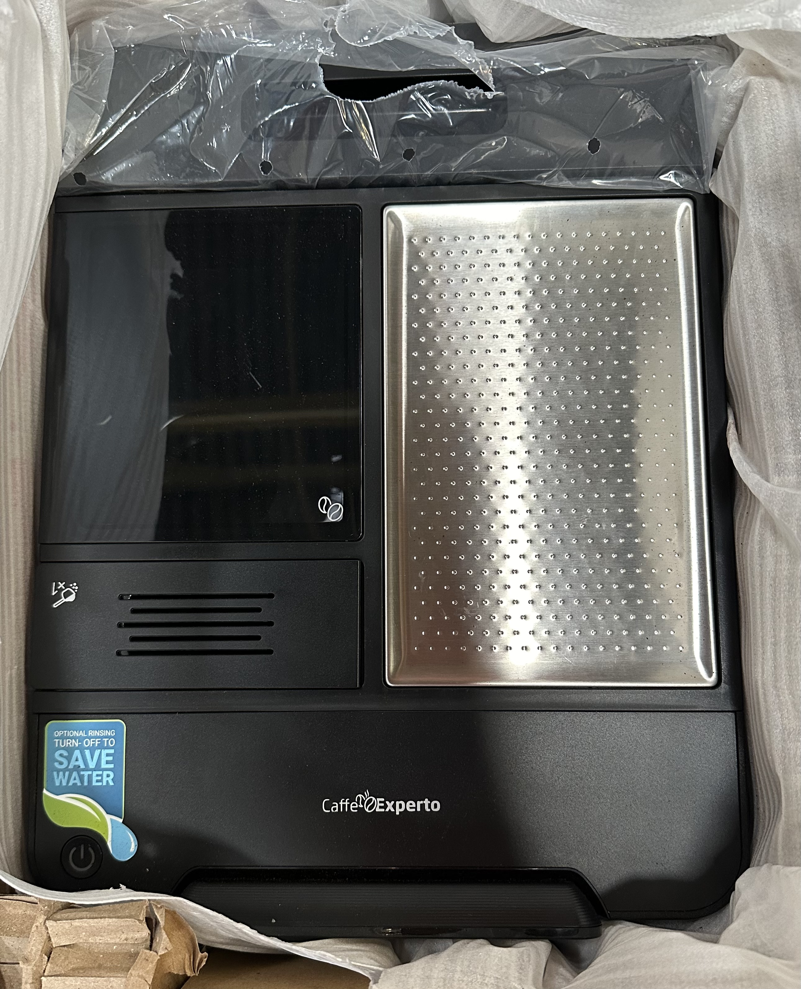 Czarny ekspres do kawy ze srebrnym blatem i czarnym panelem sterowania.