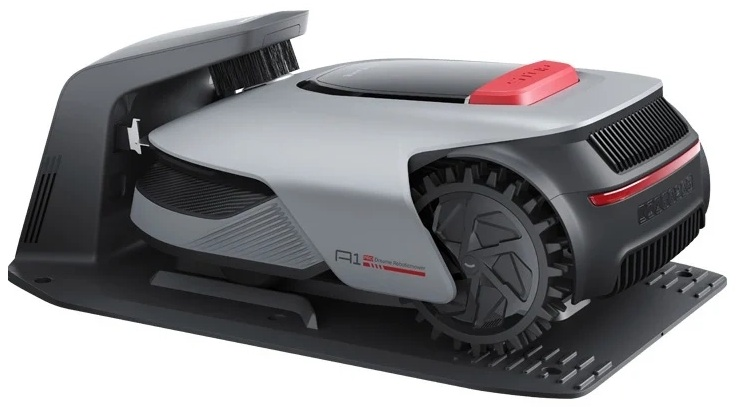 Roboty koszący na czarnej podstawie, szary korpus, czerwony wierzch i czarne koła.