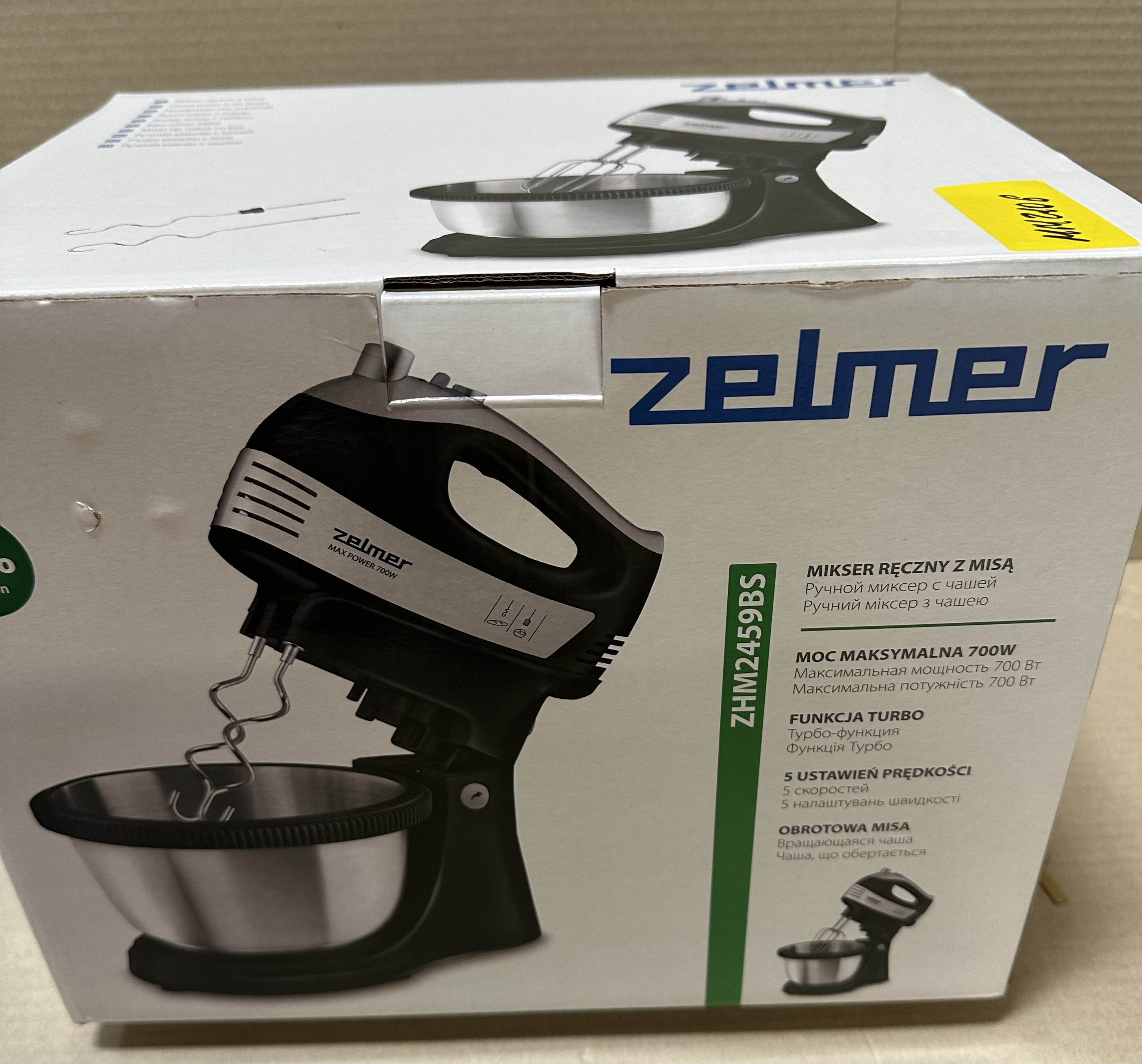 Czarny i srebrny mikser Zelmer z pudełkiem. Jest na białym tle.