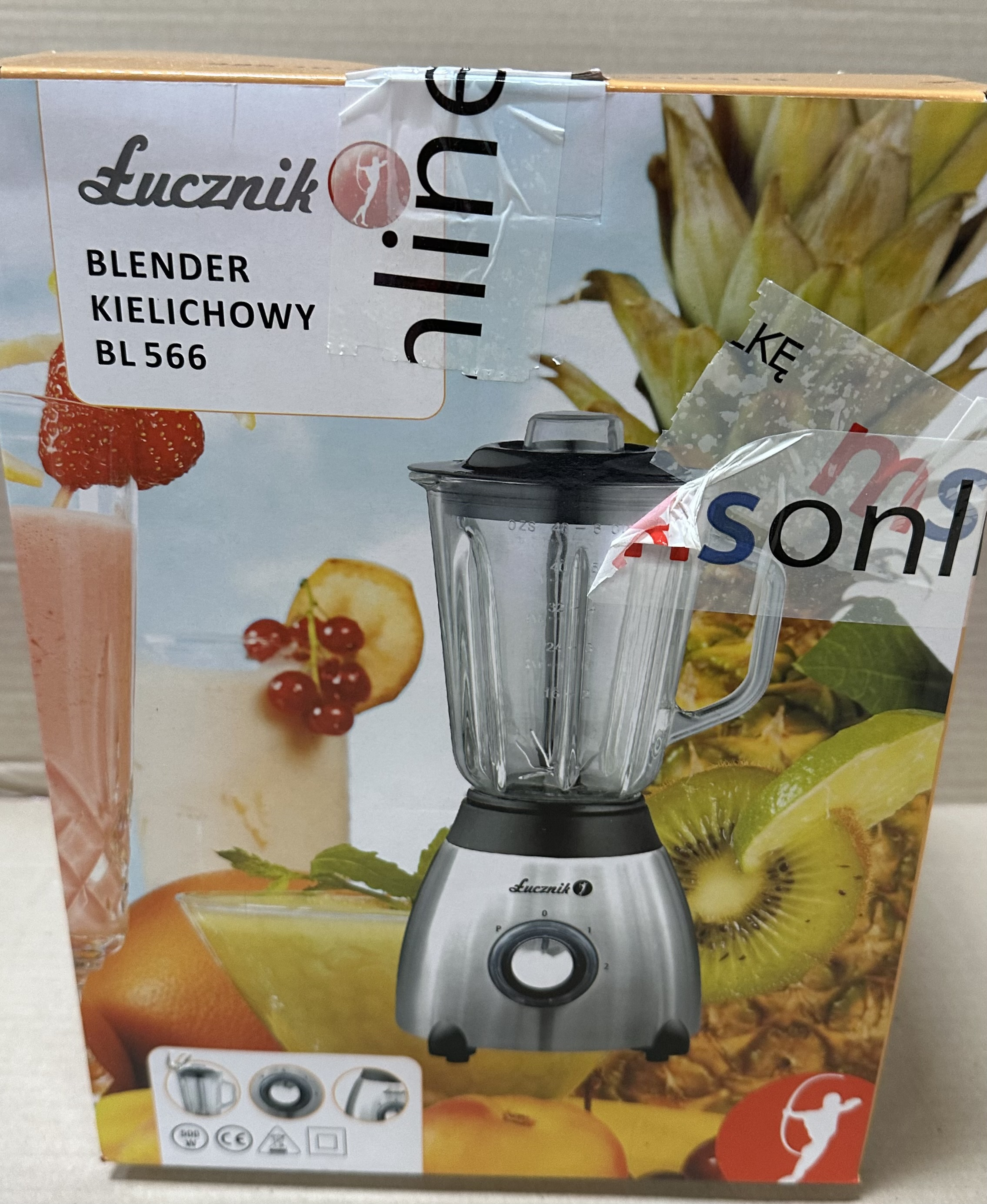 Blender Lucznik w pudełku ze zdjęciem koktajlu i owoców.
