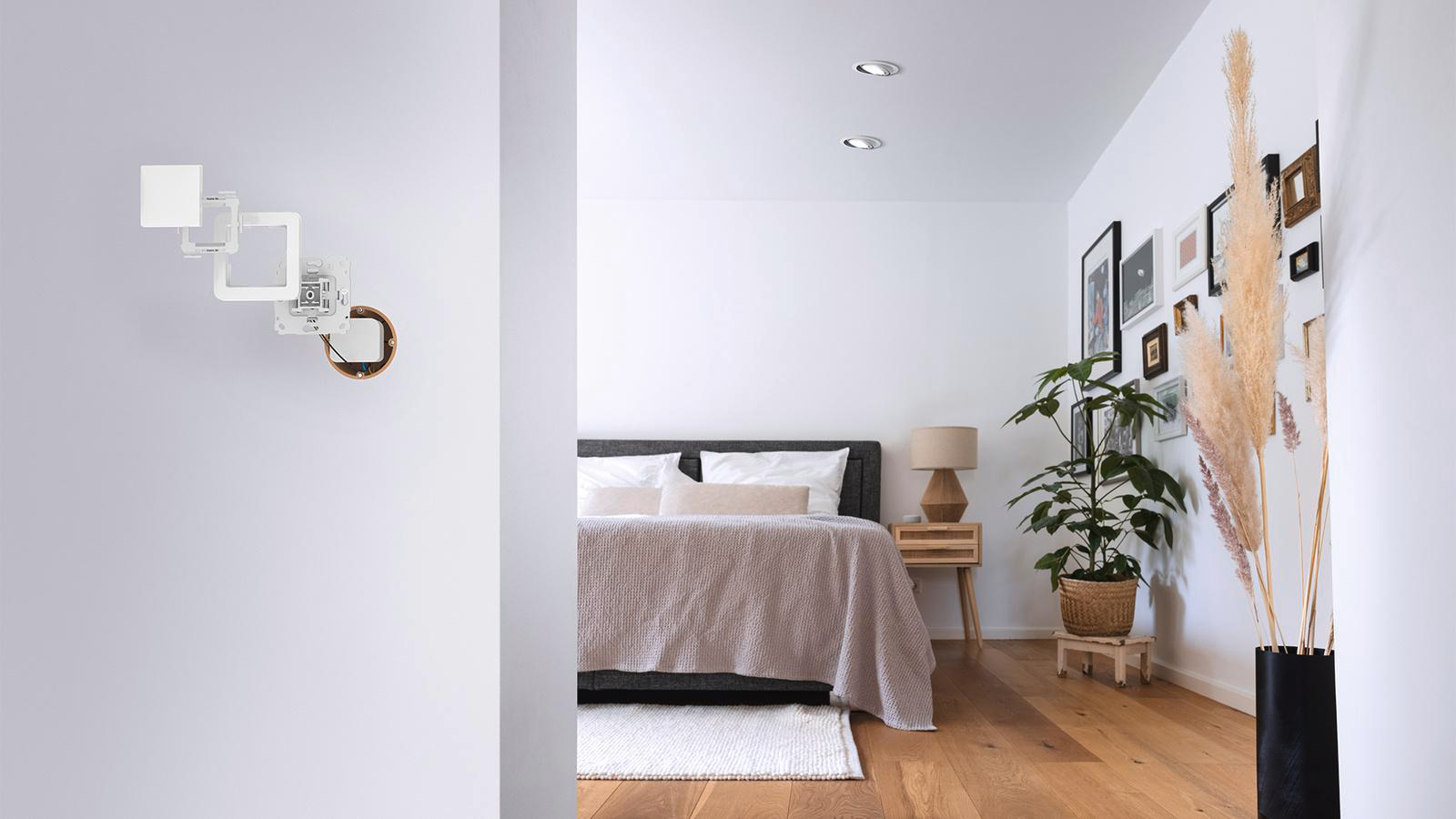 Ein modernes Schlafzimmer-Interieur mit Bett, Kunstwerken und einer Pflanze.