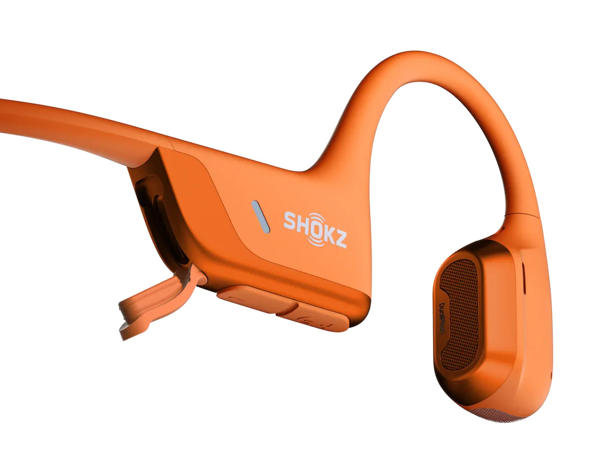 Pomarańczowe słuchawki Shokz. Słuchawki są na białym tle.