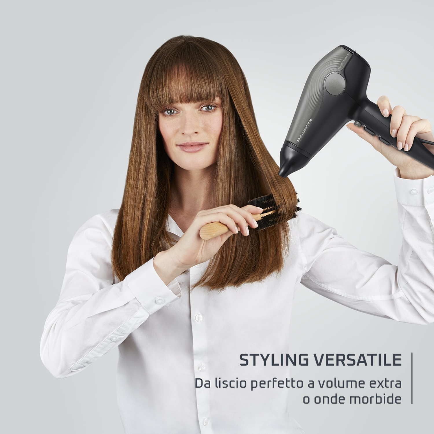 Donna che si acconcia i capelli con un asciugacapelli e una spazzola. Il testo dice 'Styling Versatile'.